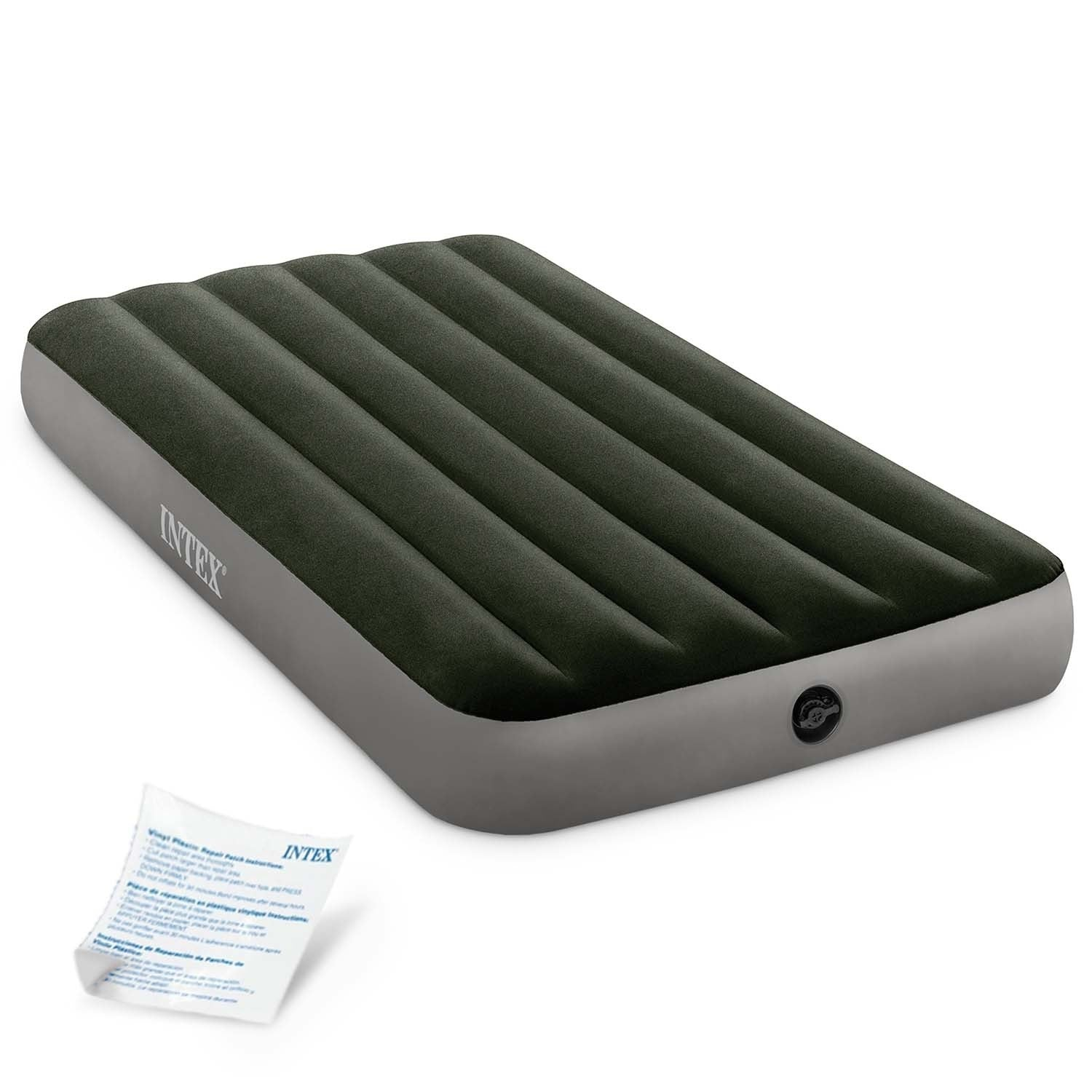 Un colchón inflable, verde oscuro con lados grises, la marca INTEXT es visible, con un pequeño kit de reparación.