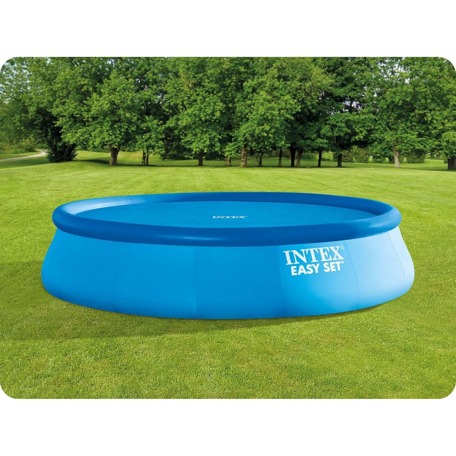 Una piscina azul Intex Easy Set sobre césped verde. Los árboles forman el fondo.