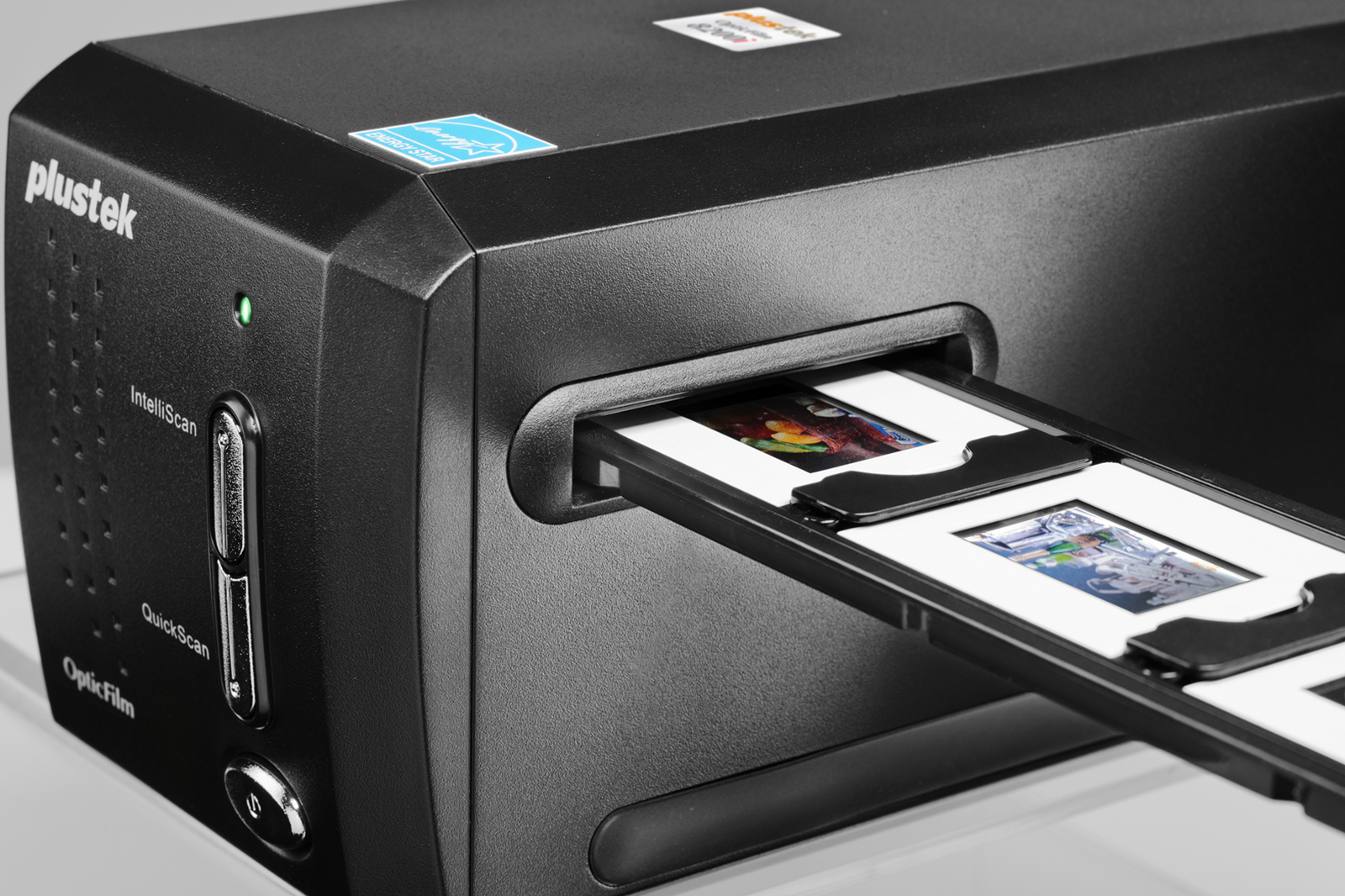 Czarny skaner Plustek z wsuwanymi slajdami. Skaner ma zielone światło i naklejkę Energy Star.