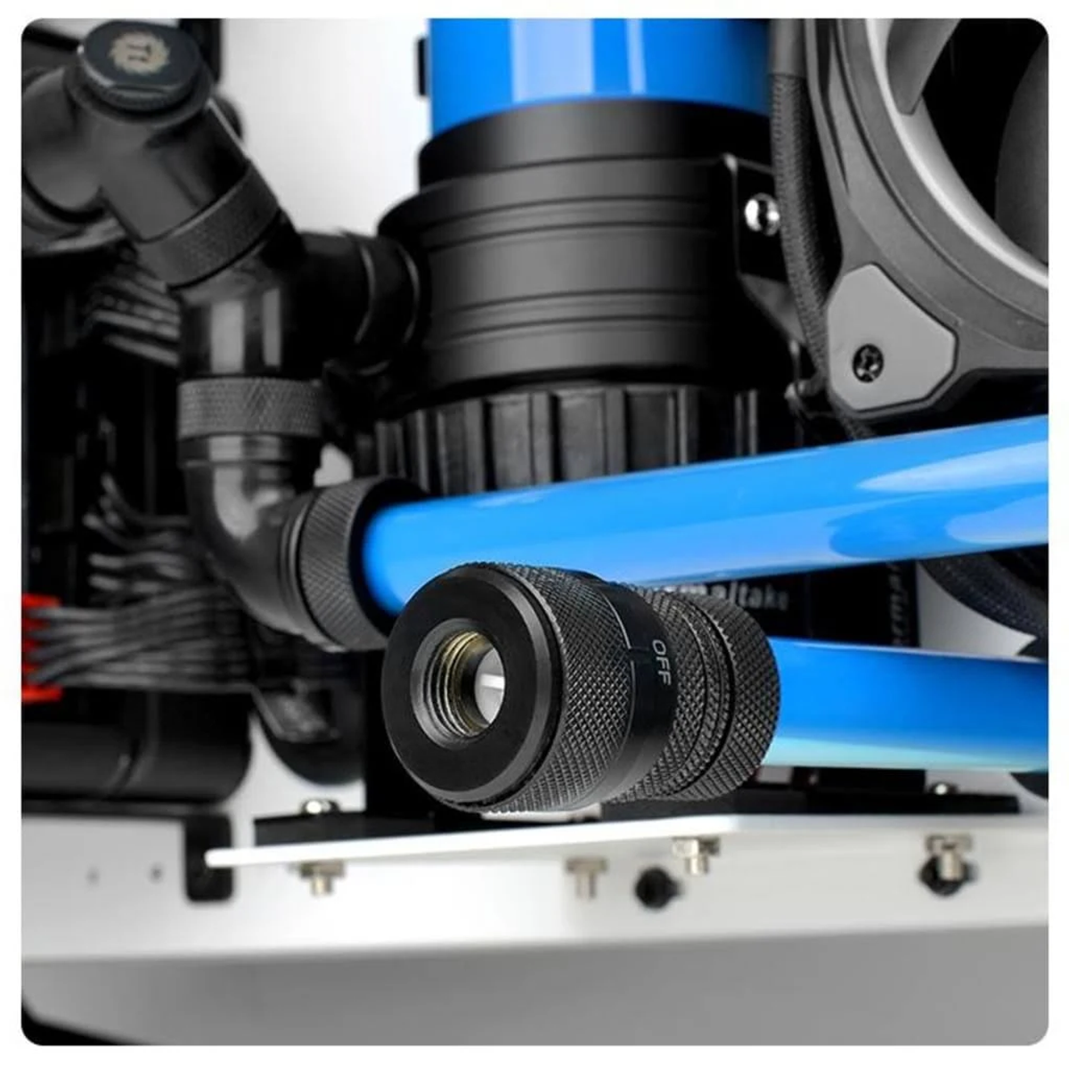 Primer plano de un sistema de refrigeración por agua para PC. Se ven tubos azules, conexiones negras y un componente cilíndrico negro.