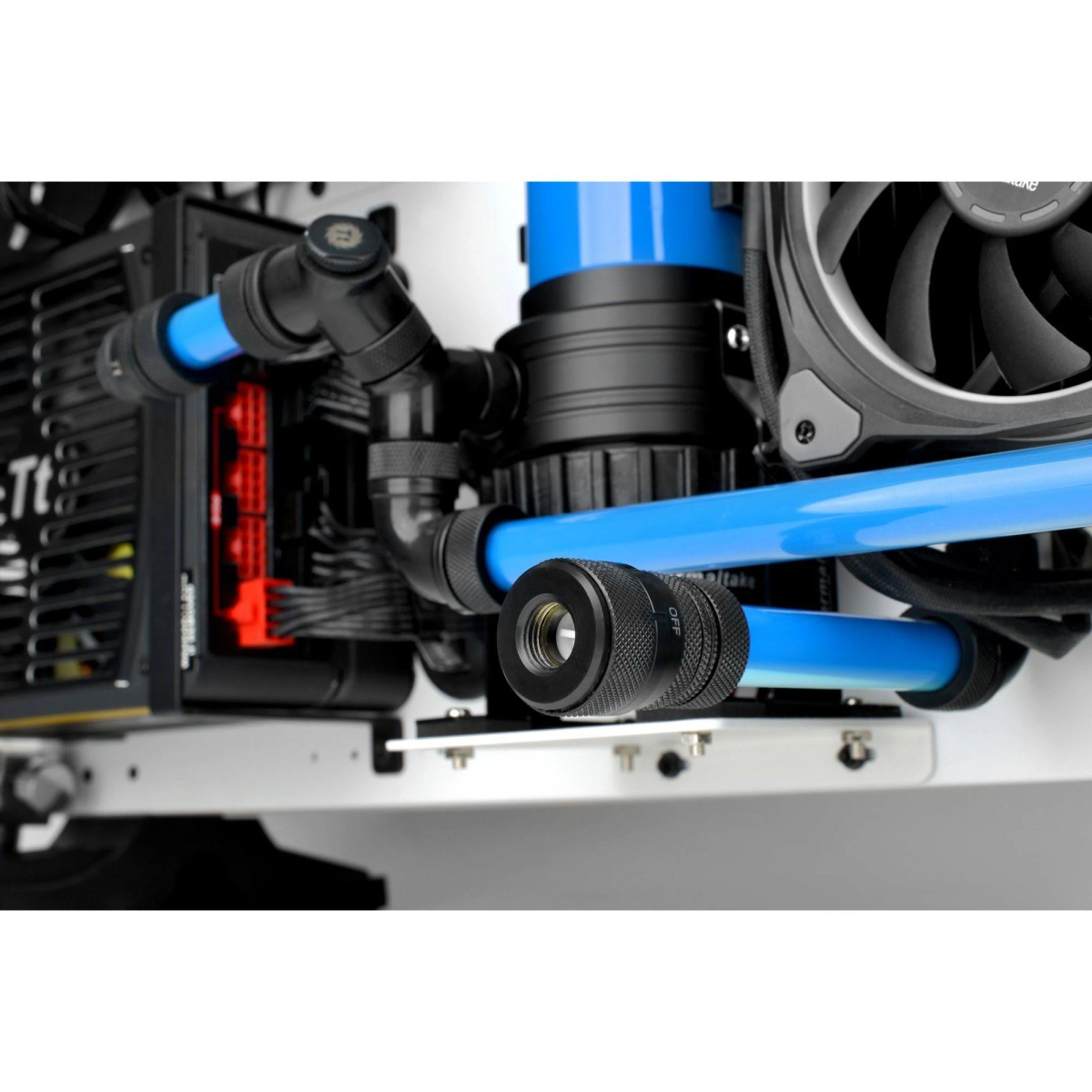 Se muestra un sistema de refrigeración por agua de una computadora. Tubos azules se conectan a accesorios negros y un componente cilíndrico negro. Se ve un ventilador.