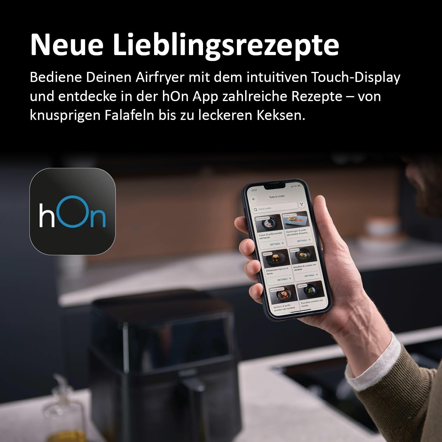 Eine Person hält ein Telefon mit Rezepten. Im Hintergrund befinden sich eine Heißluftfritteuse und ein Logo mit der Aufschrift hOn.