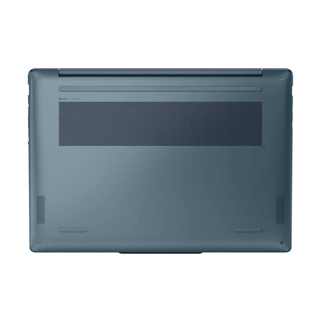 Spód tealowego laptopa. Ma otwór wentylacyjny, otwory na głośniki i małe nóżki.