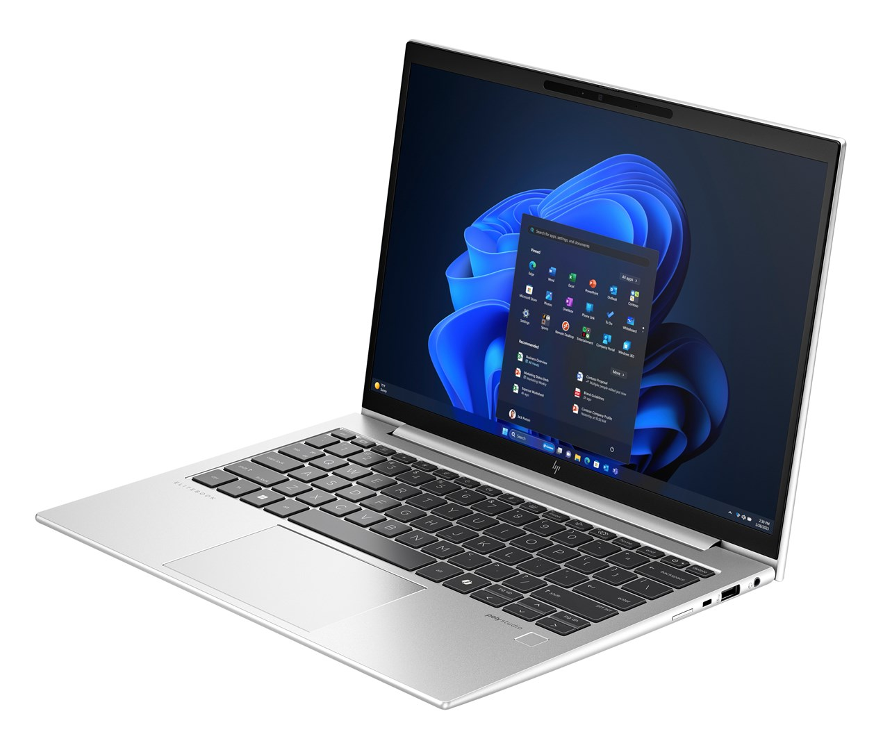 Srebrny laptop wyświetla interfejs Windows 11. Ekran pokazuje menu Start z ikonami aplikacji. Widoczna klawiatura i touchpad.