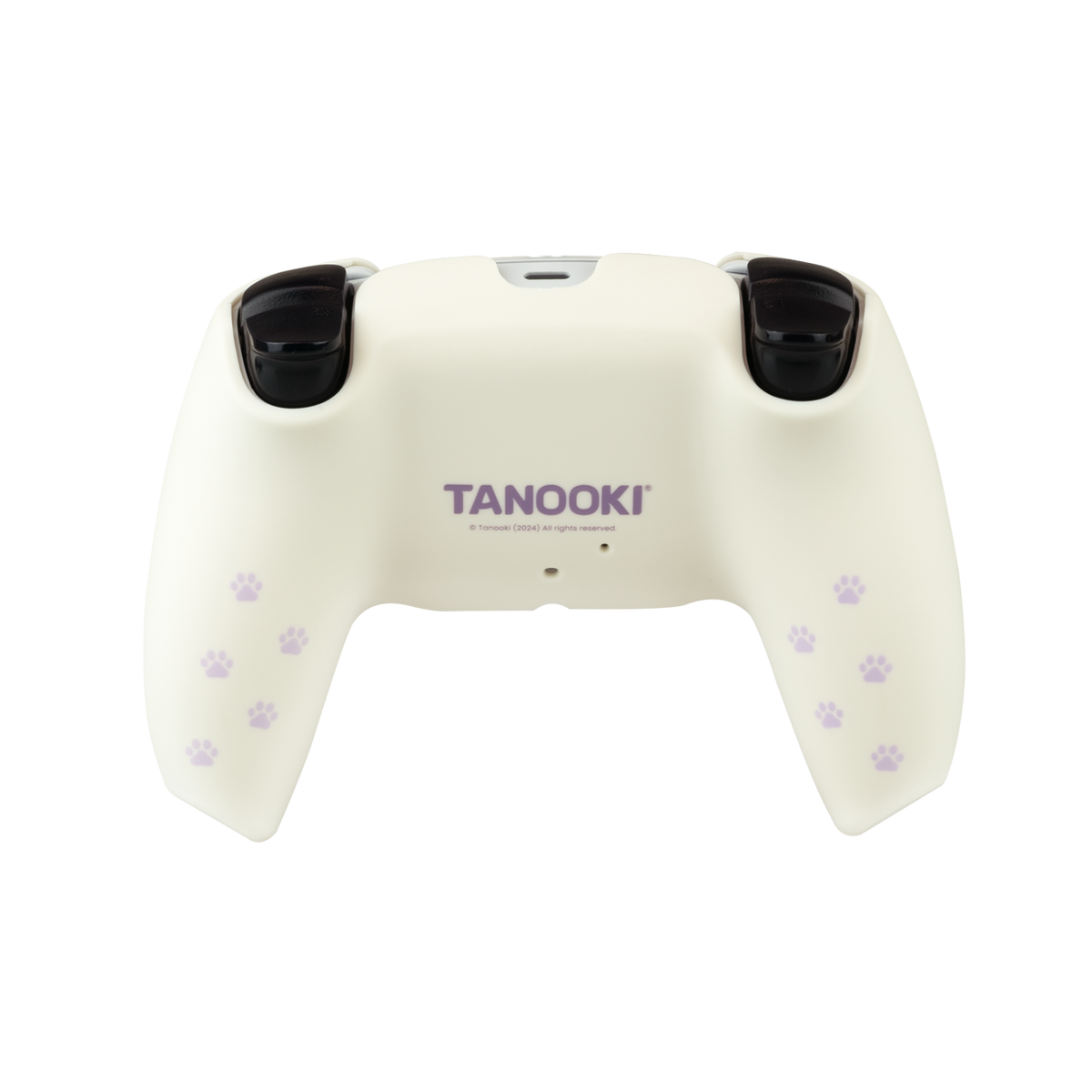 Controlador de juego crema con botones negros. Presenta huellas de patas moradas y la palabra 'TANOOKI'. El fondo es negro.