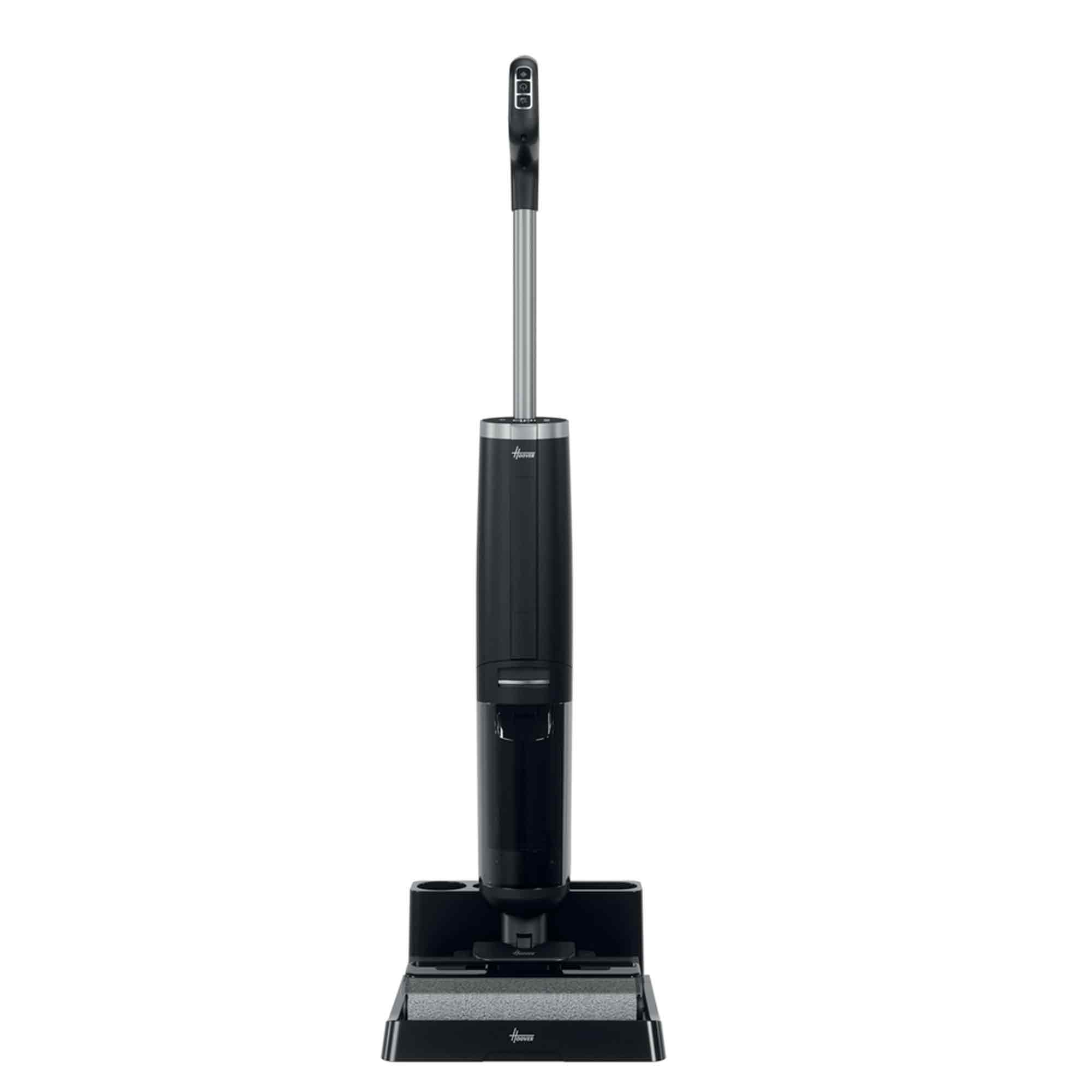 Un aspirateur vertical noir et argenté sur fond blanc. Il a une longue poignée et une tête de nettoyage.