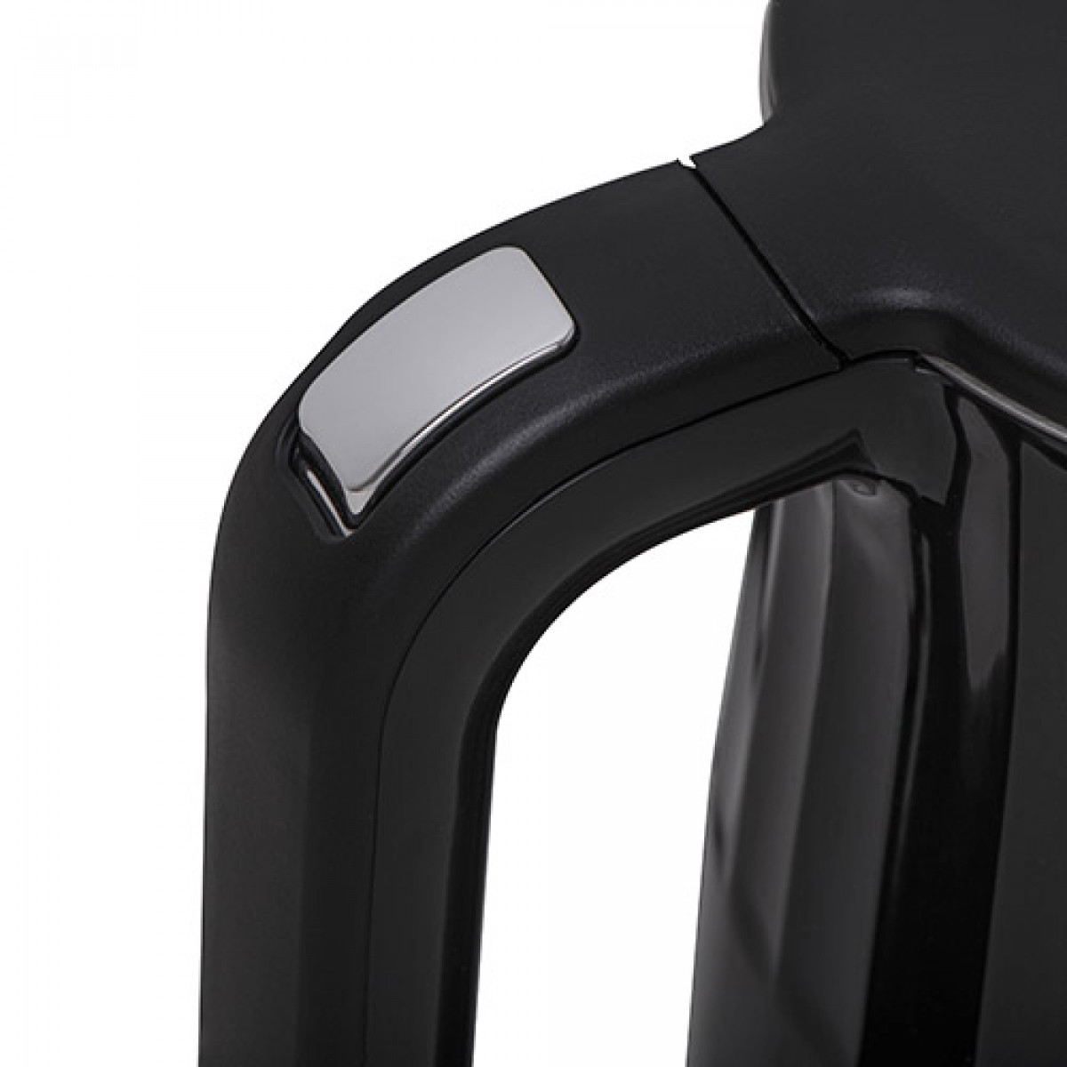 Zbliżenie czarnego uchwytu czajnika ze srebrnym przyciskiem. Uchwyt zakrzywia się w prawo, z błyszczącym przyciskiem na górze.