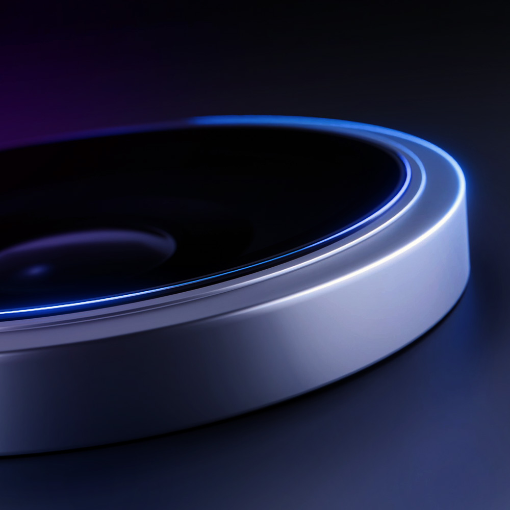 Zbliżenie metalowego, okrągłego obiektu z niebieskim neonowym światłem. Tło jest ciemne z fioletowymi odcieniami.