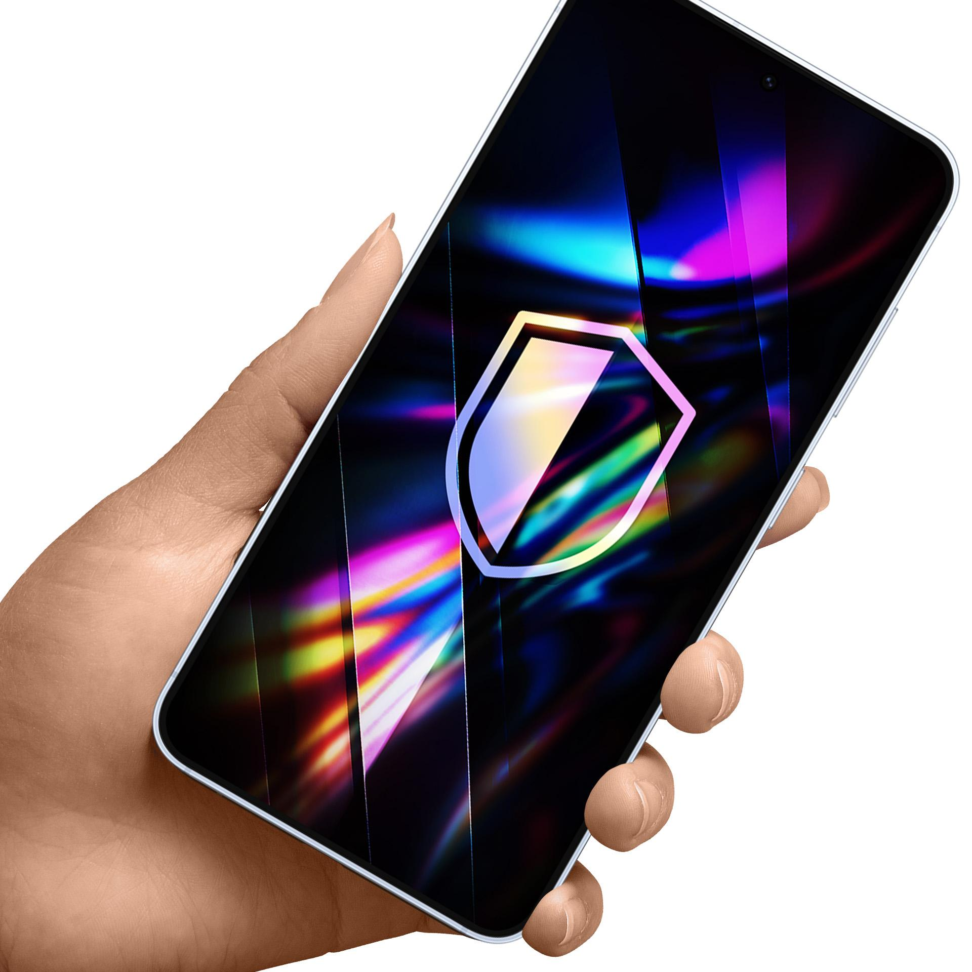 Dłoń trzymająca smartfon z logo tarczy na ekranie. Tło jest białe.