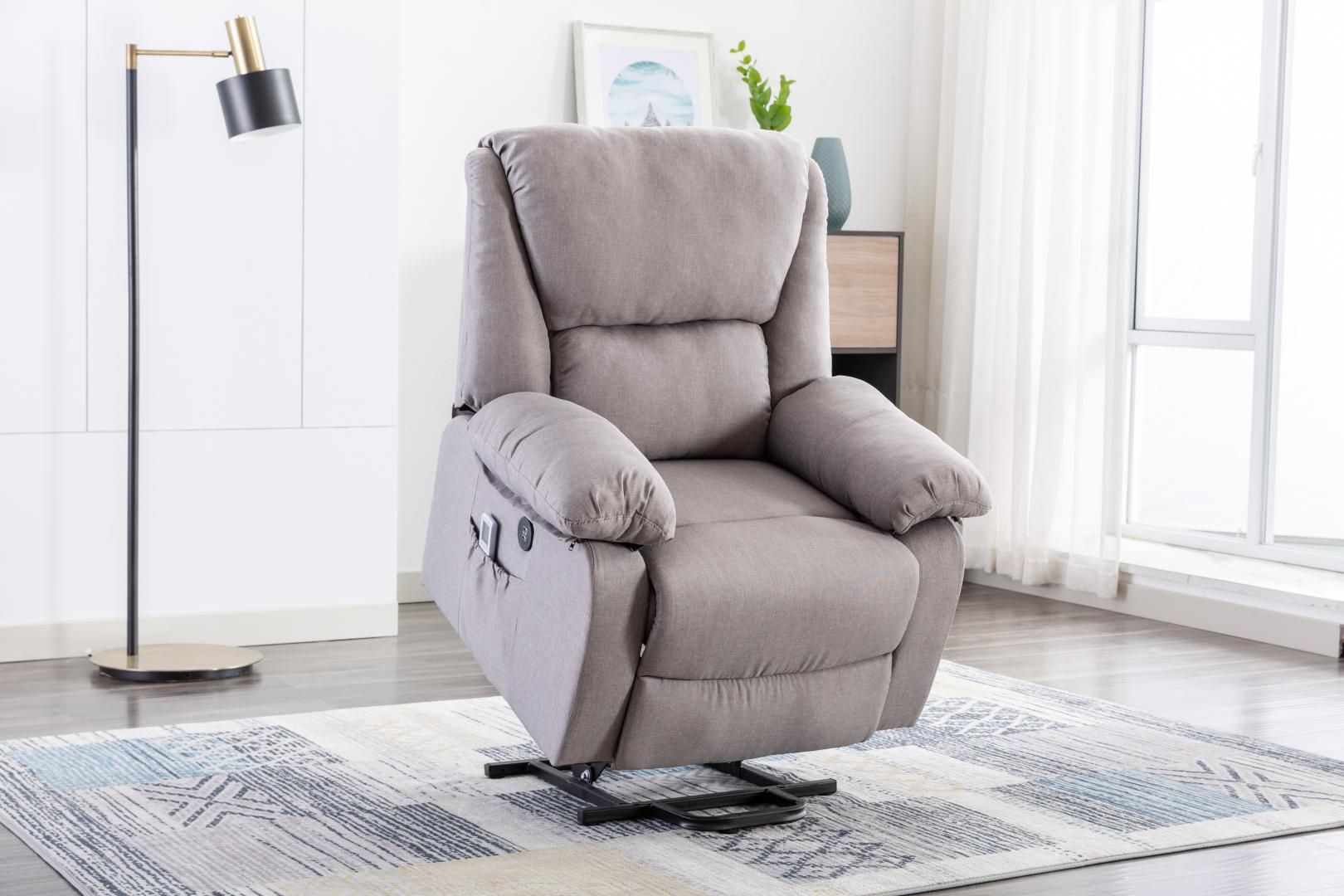 Un sillón reclinable gris en una sala de estar. Una lámpara de pie está a la izquierda. Una alfombra estampada debajo.