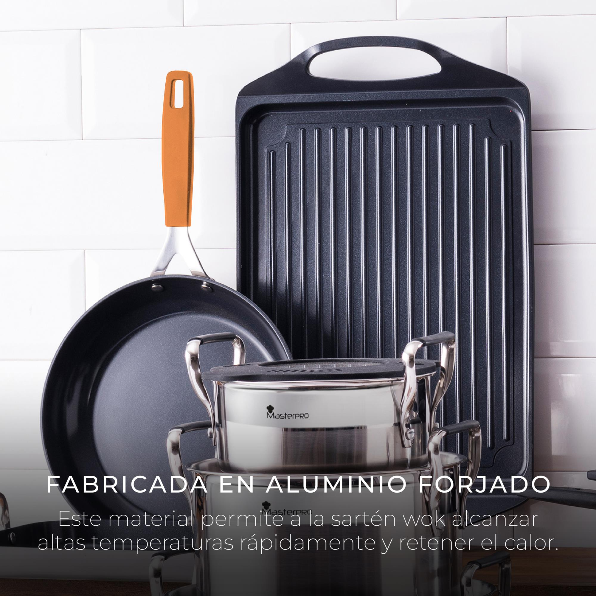 Juego de utensilios de cocina: sartén, plancha y olla. Mango naranja. Fondo de azulejos blancos. Aluminio forjado.