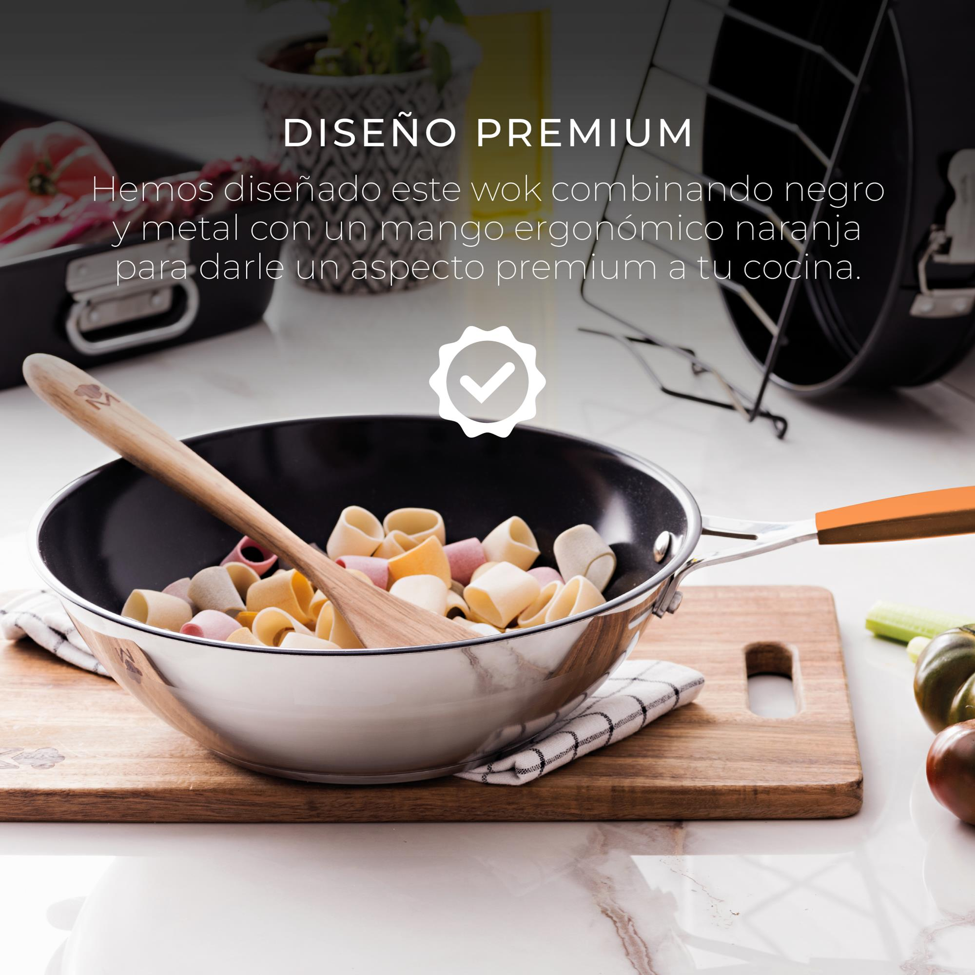 Wok con pasta y cuchara de madera sobre tabla. Mango negro y naranja. Fondo negro.