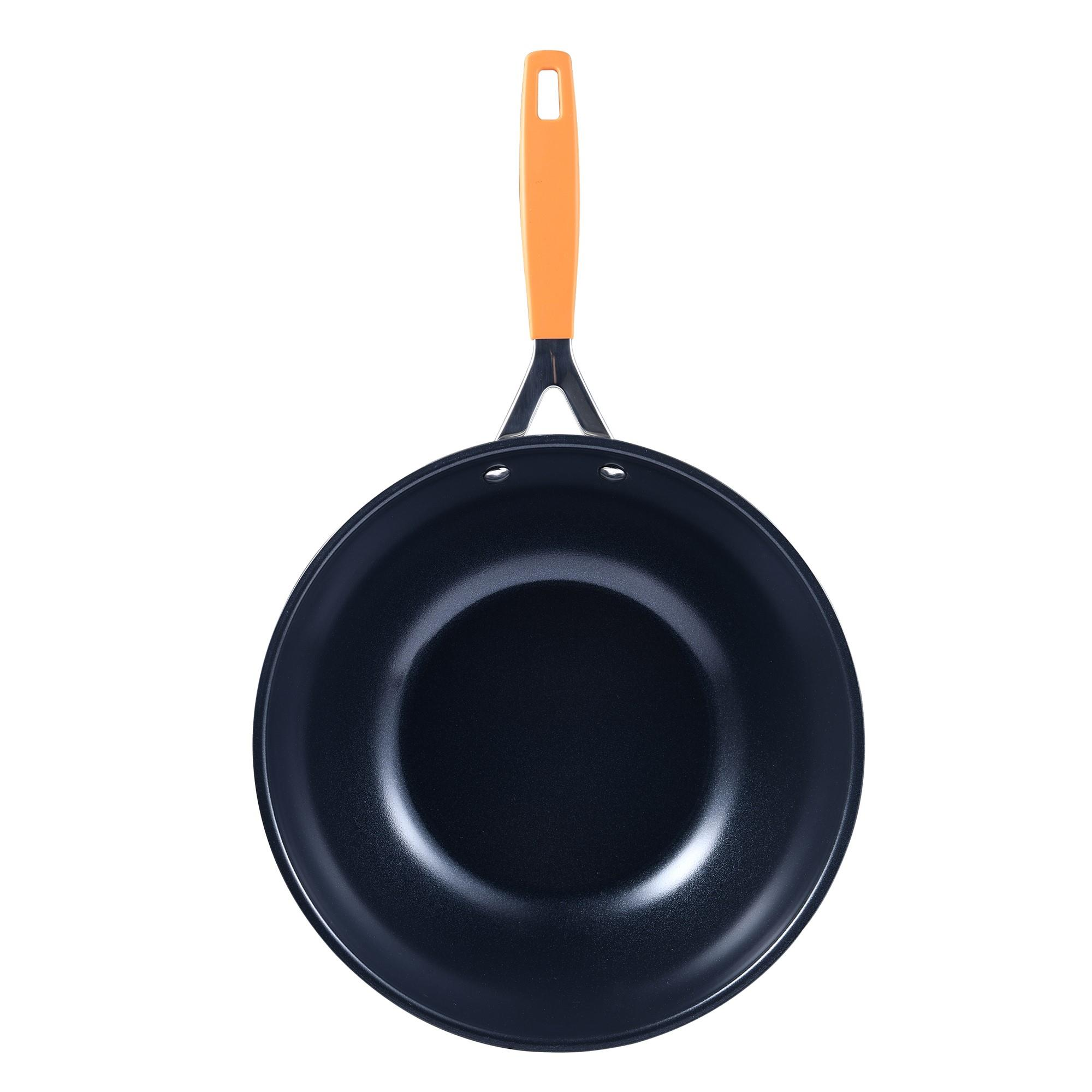Un wok azul oscuro con asa naranja. El wok está centrado sobre un fondo blanco, vista superior.