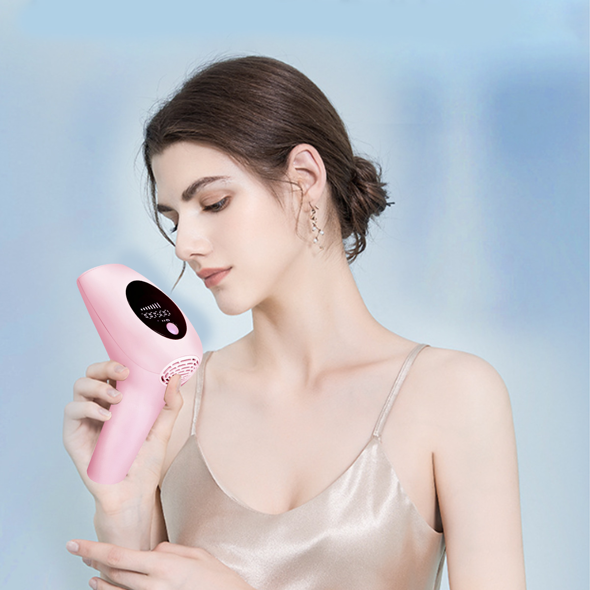 Eine Frau hält ein rosa Haarentfernungsgerät. Sie trägt ein Satintop, Ohrringe und hat braune Haare. Der Hintergrund ist hellblau.