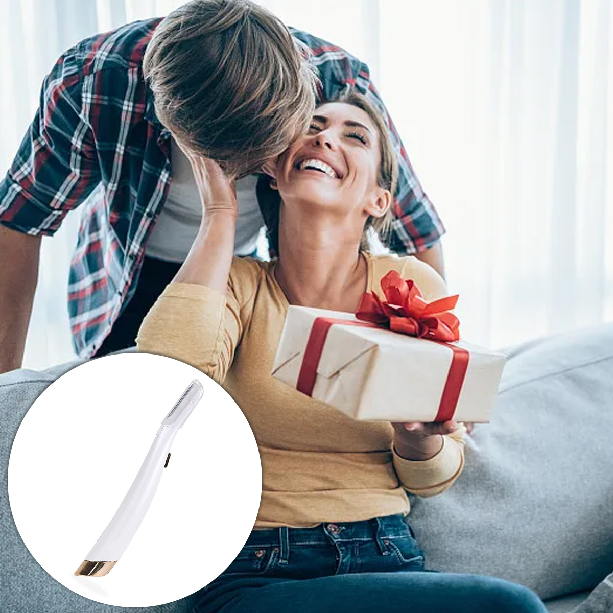 Eine lächelnde Frau hält ein Geschenk, ein Mann küsst sie. Ein weißes Beauty-Tool im Vordergrund, sie sitzen auf einem Sofa.