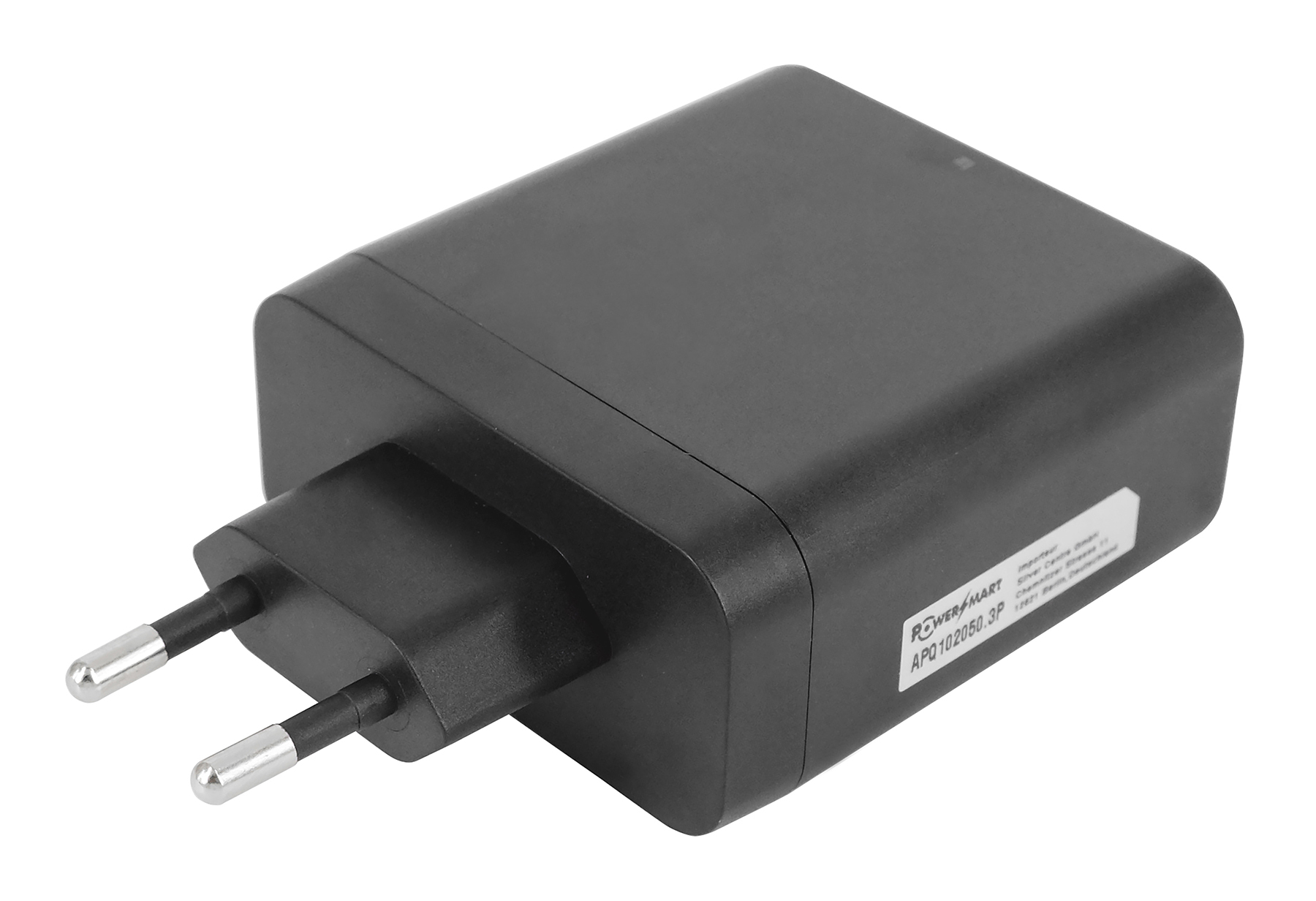 Ein schwarzes Netzteil mit silbernen Stiften. Der Adapter hat einen rechteckigen Körper mit abgerundeten Kanten. Weißes Etikett an der Seite.