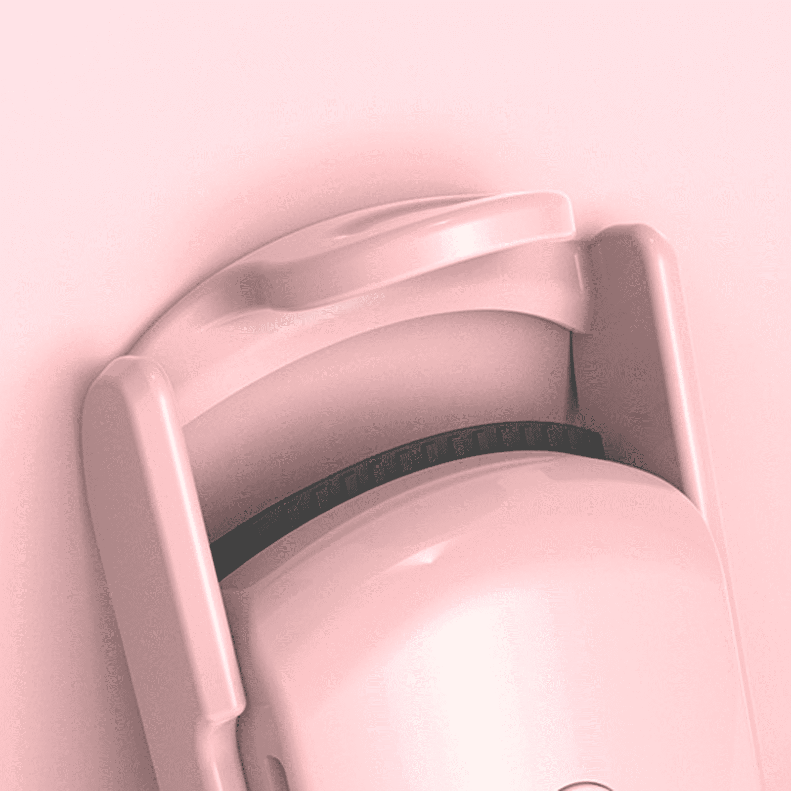Nahaufnahme eines rosa Wimperncurlers. Der Curler befindet sich vor einem rosa Hintergrund. Der Curler hat ein schwarzes Gummipad.