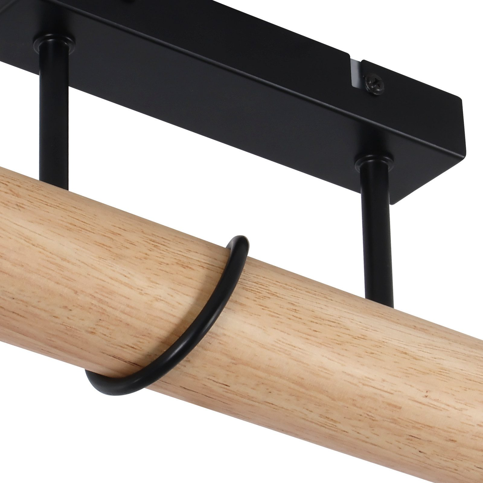 Primo piano di un lampadario. Ha una trave di legno, supporti in metallo nero e un anello nero.