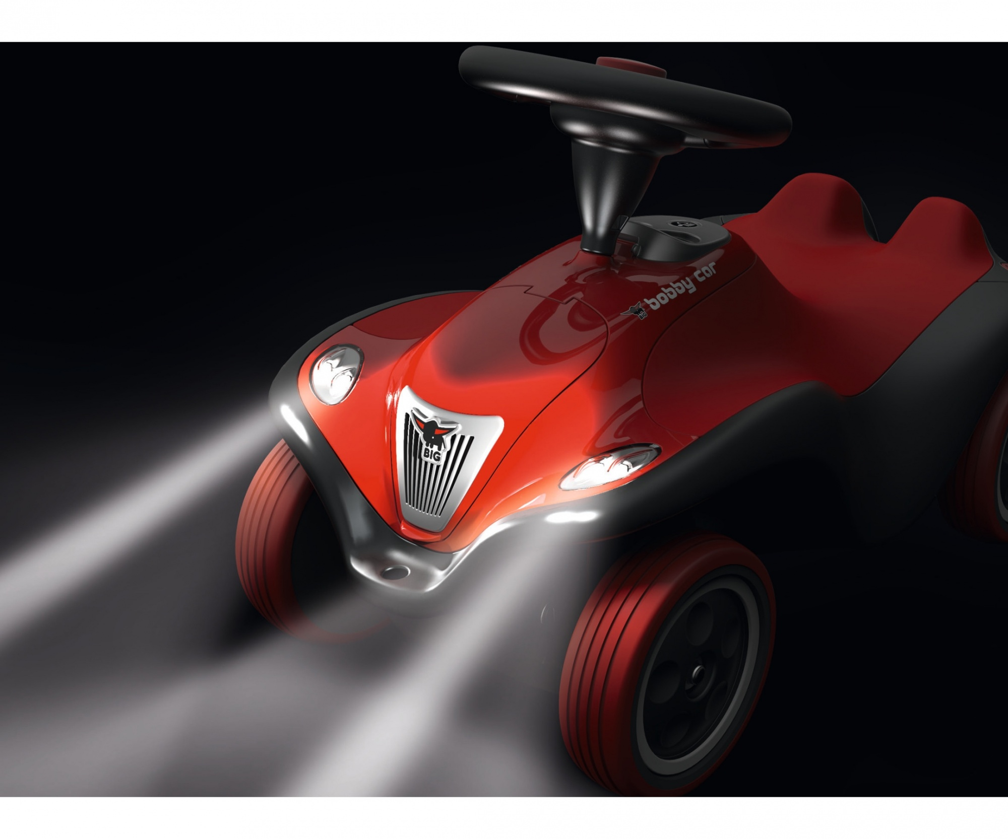 Ein rot-schwarzes Spielzeugauto mit Scheinwerfern. Das Auto hat ein Lenkrad und vier Räder. Der Hintergrund ist schwarz.