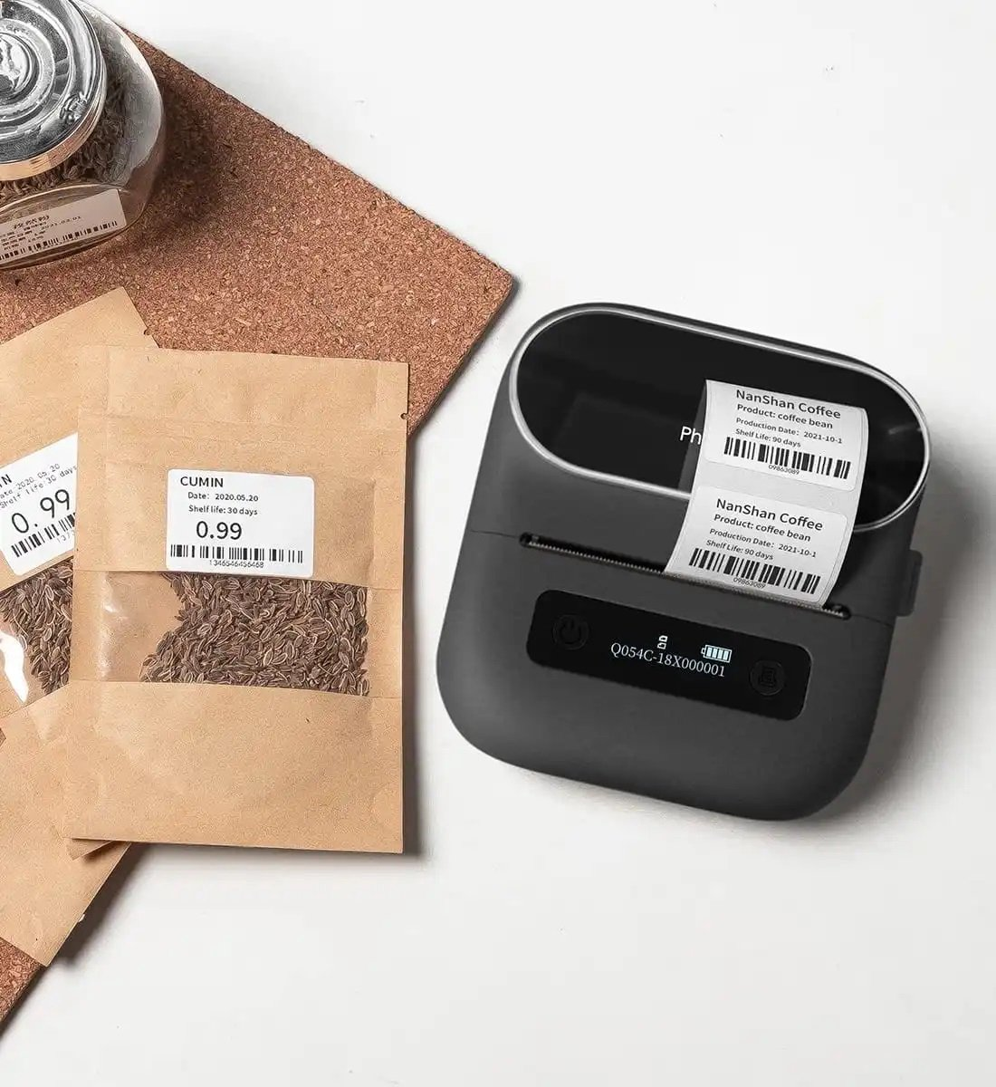 A label printer next to cumin packets and a jar. Labels with coffee details are being printed.