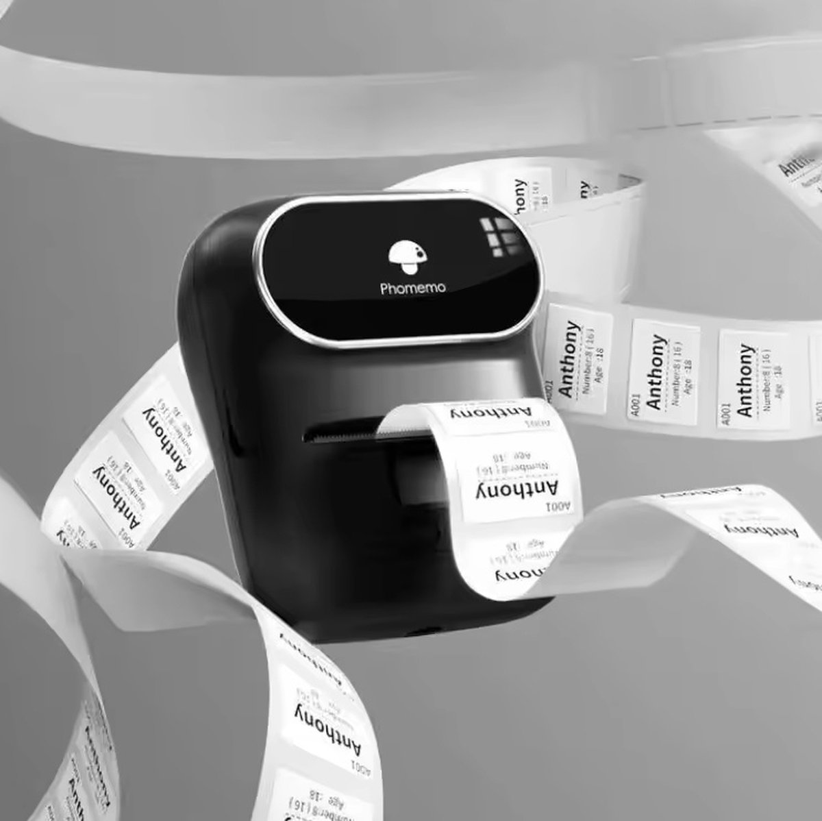 Een zwarte Phomemo-labelprinter print labels met de naam Anthony. Labels staan ​​op een rol, sommige zijn al bedrukt.