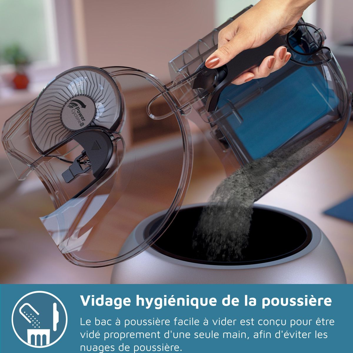 Ręka opróżnia pojemnik na kurz odkurzacza. Pył spada do ciemnego otworu. Części odkurzacza są przezroczyste.