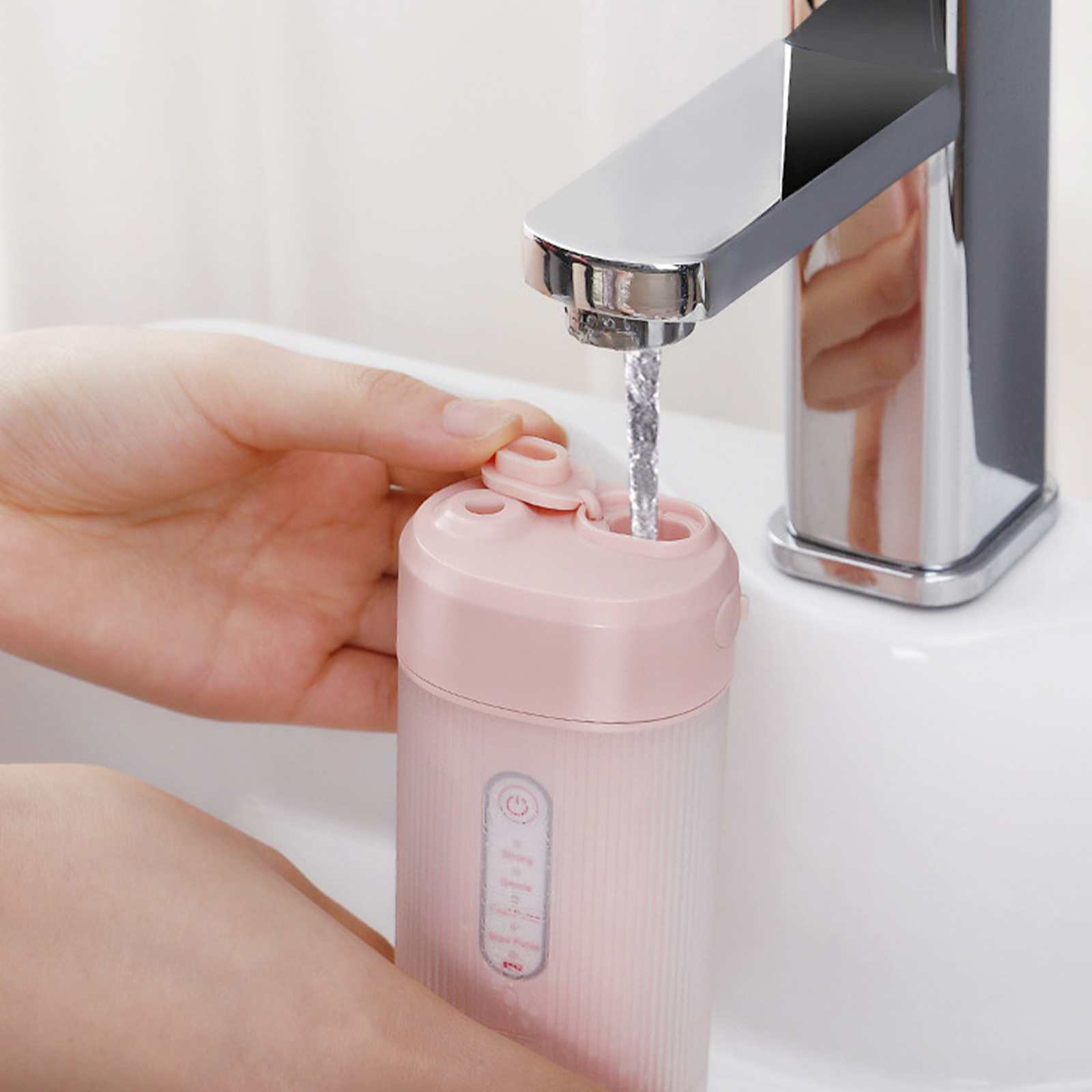 Eine Person füllt eine rosa Wasserflasche unter einem Chromhahn. Wasser strömt in die Flasche.