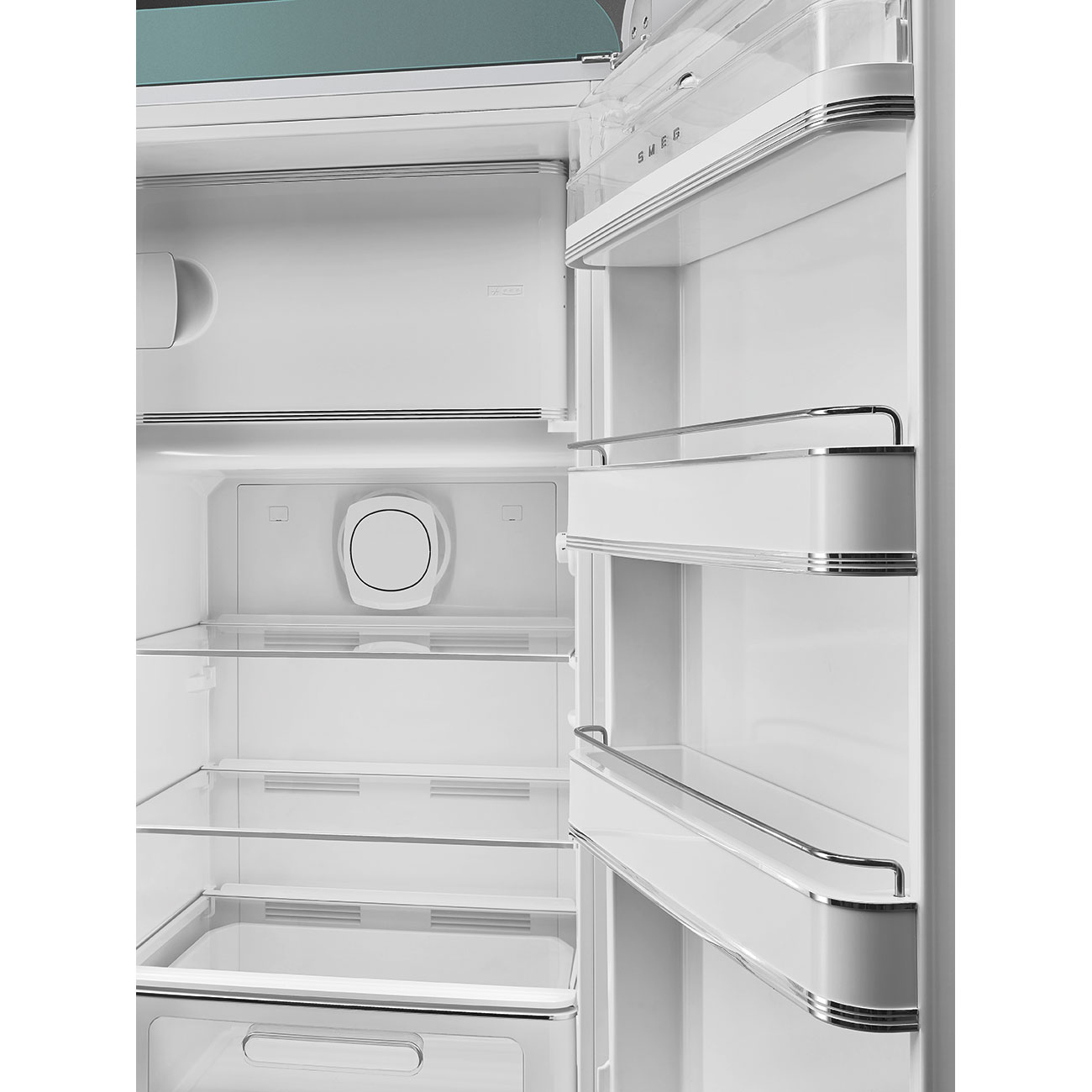 Offener weißer Kühlschrankinnenraum mit Regalen und Schubladen. Der Markenname SMEG ist sichtbar. Silberne Verkleidung. Glasböden.