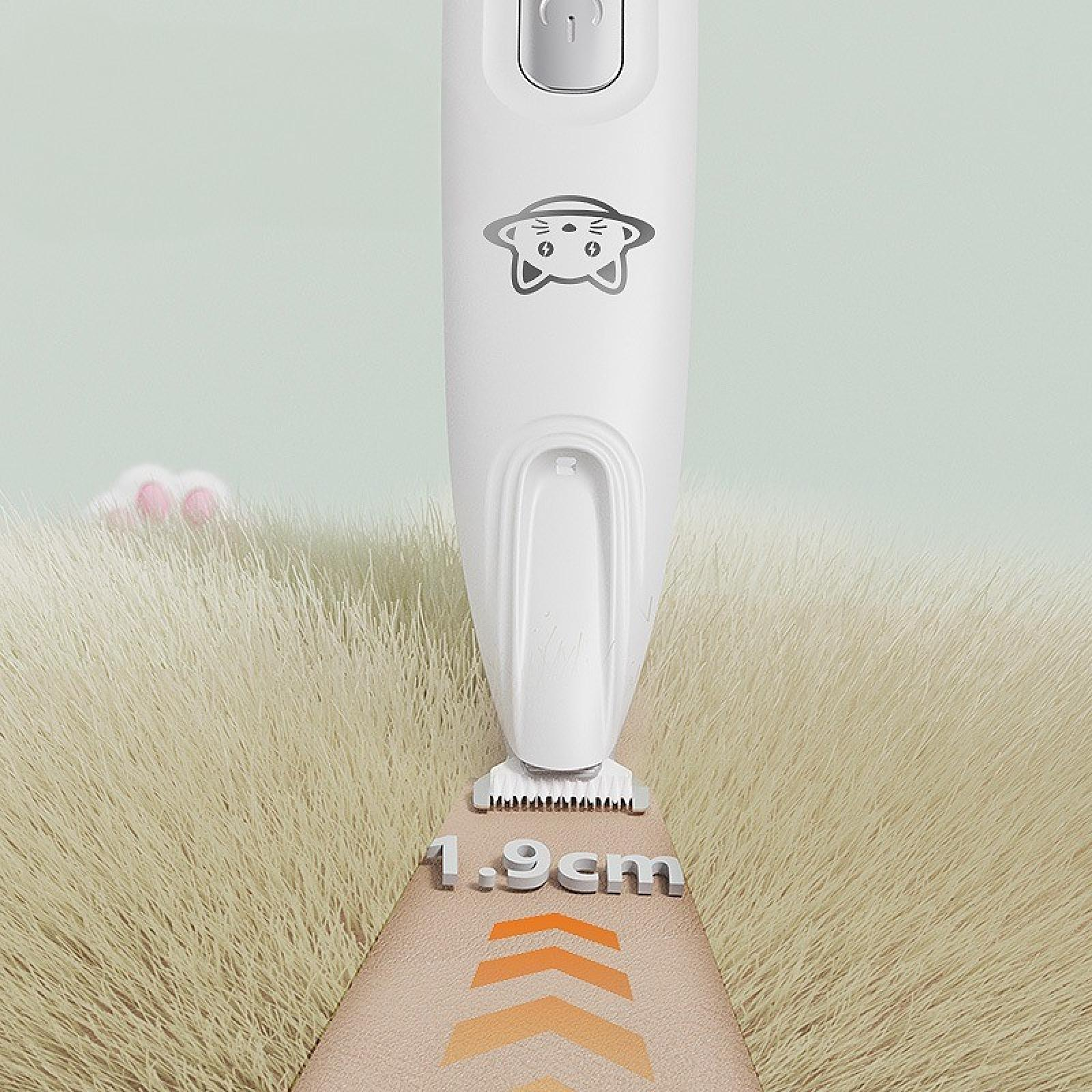 Weißer Tierhaarschneider mit Katzenlogo, misst 1,9 cm. Beiges Fell im Hintergrund. Rosa Hasenohren schauen aus dem Gras.