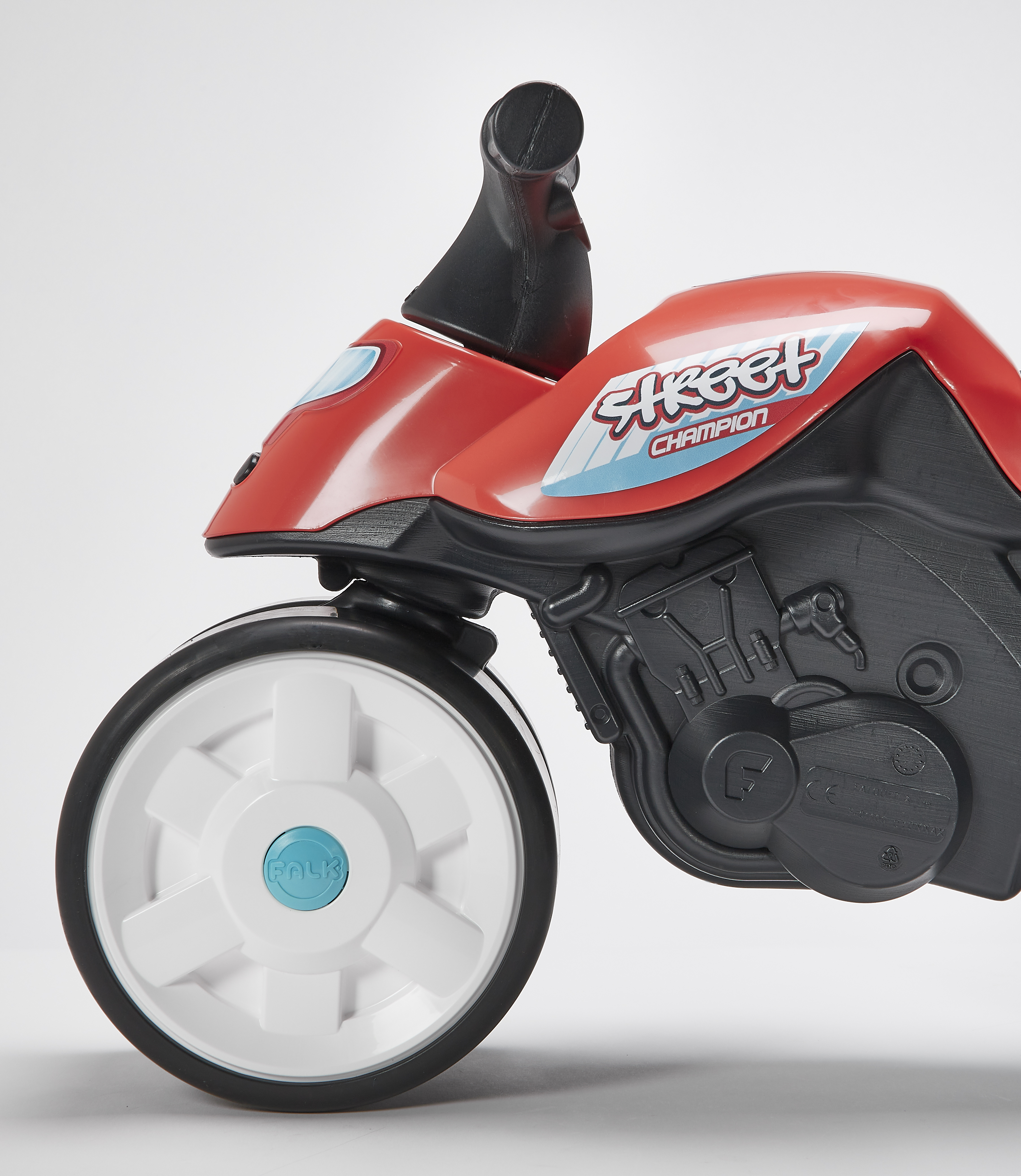 Ein rotes und schwarzes Spielzeugmotorrad steht auf weißem Hintergrund. Das Fahrrad hat weiße Räder und das Wort Street Champion.