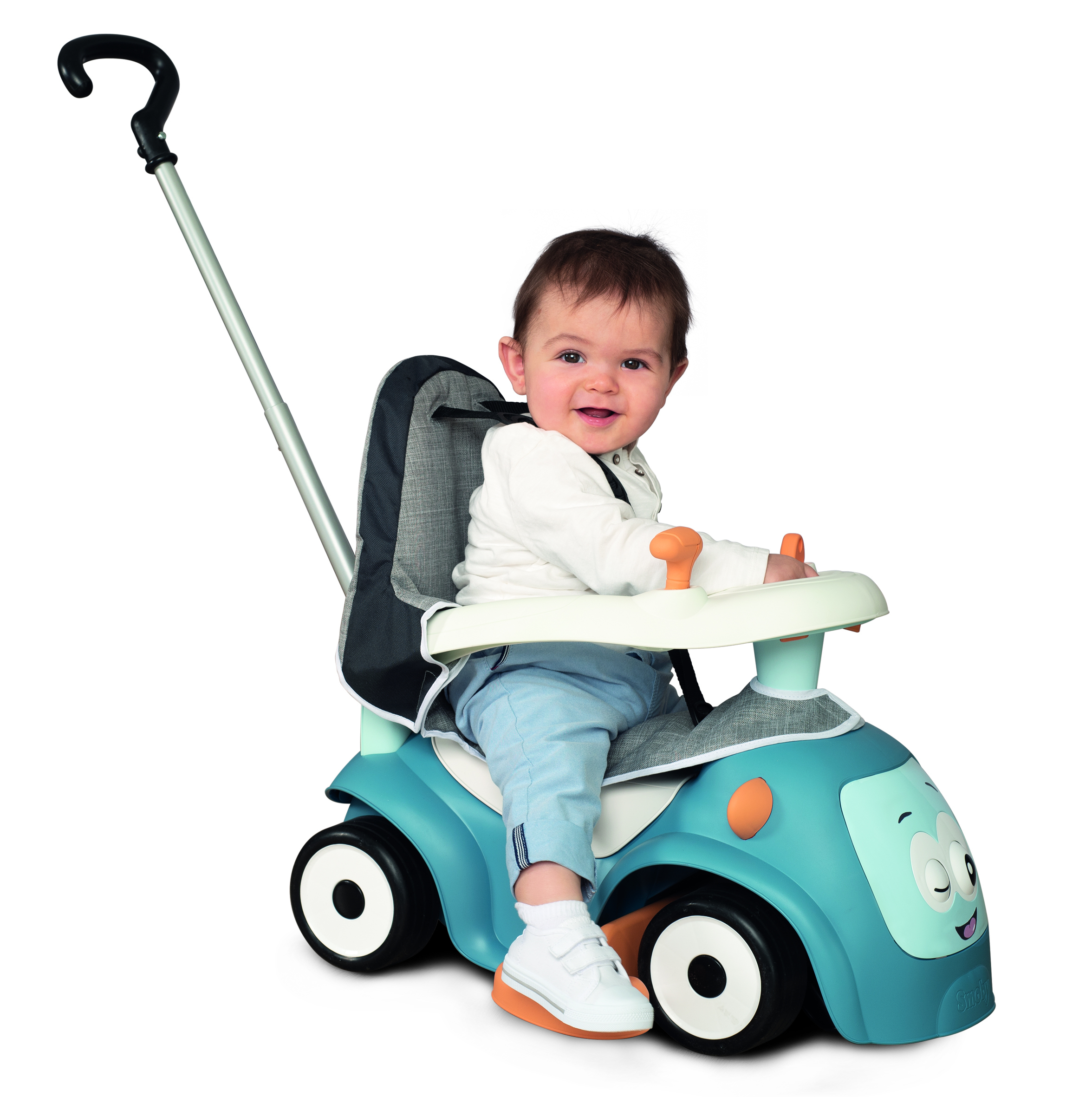 Ein Baby sitzt lächelnd in einem blauen Spielzeugauto. Das Auto hat einen Schiebegriff. Das Baby trägt ein weißes Hemd und blaue Hosen.