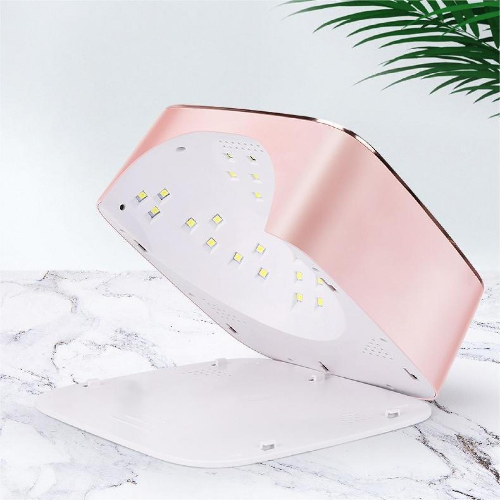 Eine roségoldene Nagellampe mit weißem Innenraum, LEDs und abnehmbarer weißer Basis auf Marmor.