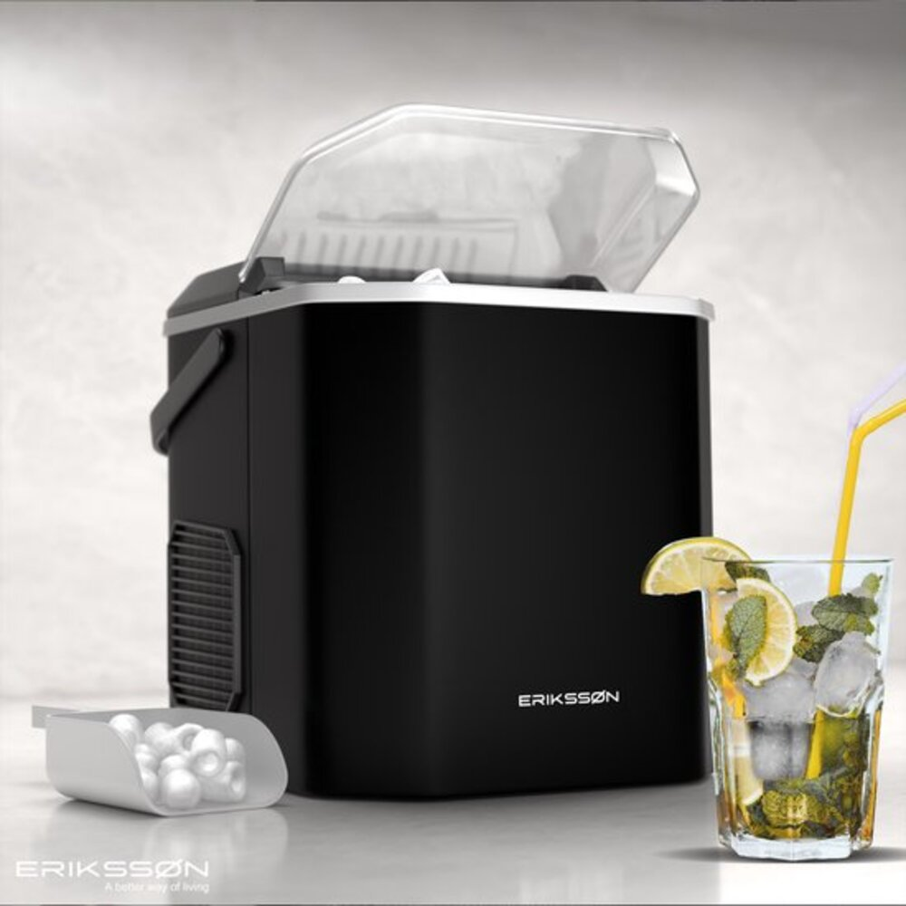 Black ice maker with open lid, ice scoop, and a glass of mojito. It has lemons, mint, and ice cubes. The brand is Eriksson.