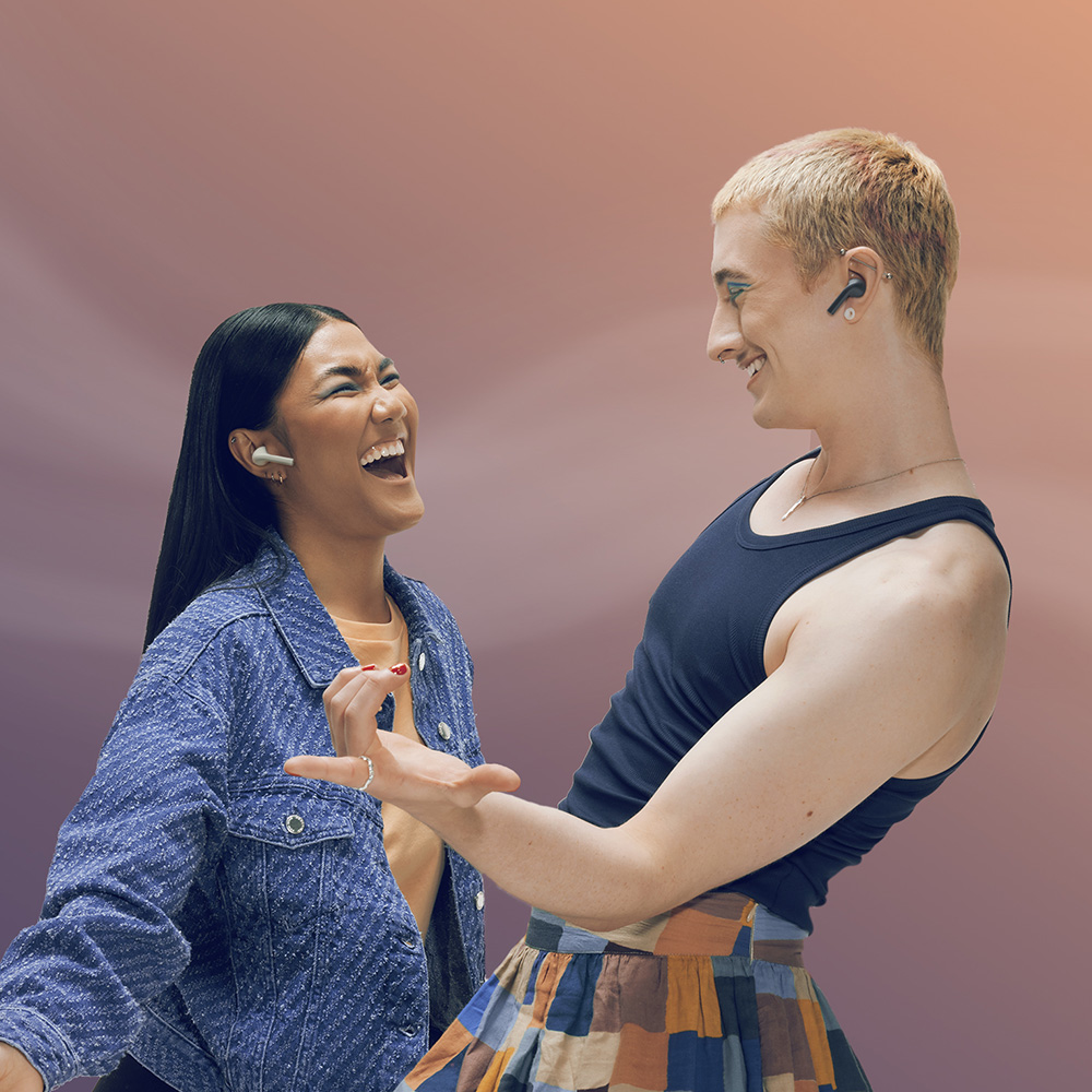 Twee mensen met oortjes lachen. Eén in spijkerstof, de ander in een tanktop en rok. Beiden lachen met een abstracte achtergrond.