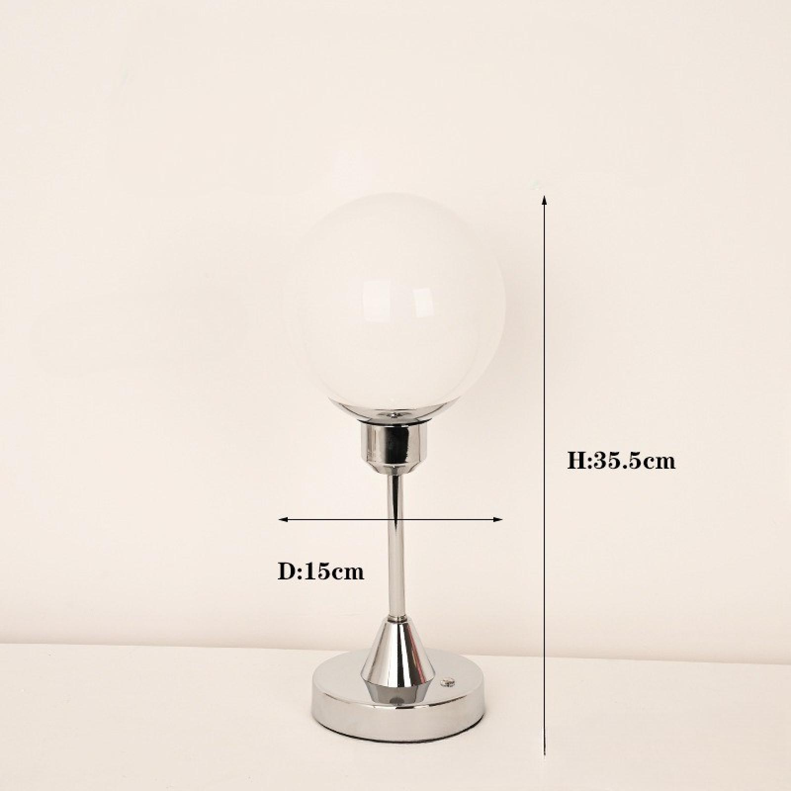 Eine moderne Lampe mit weißem Globus-Schirm, Chromfuß und -schaft. Maße: H:35,5 cm, D:15 cm. Vor weißem Hintergrund.