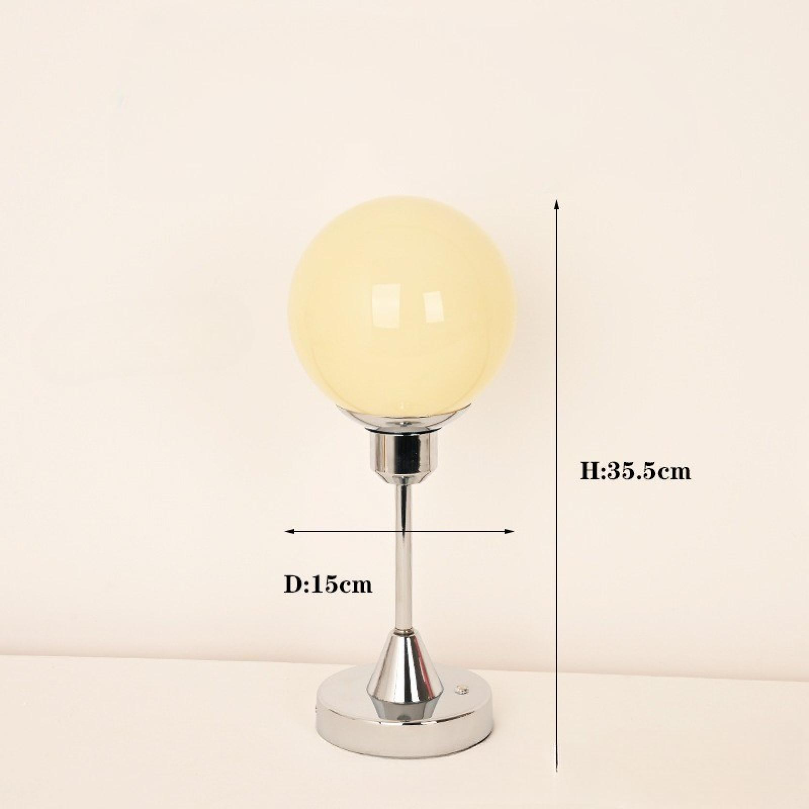 Eine moderne Lampe mit einer kugelförmigen Glühbirne auf einem Chromständer. Abmessungen: H 35,5 cm, D 15 cm.