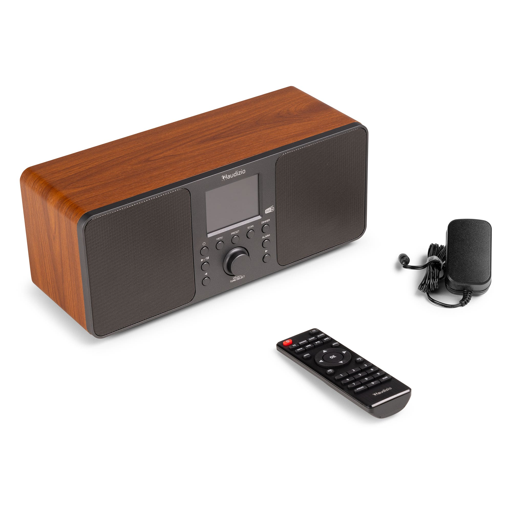 Una radio de madera con mando a distancia y adaptador de corriente sobre una superficie blanca. La radio tiene una pantalla y botones.