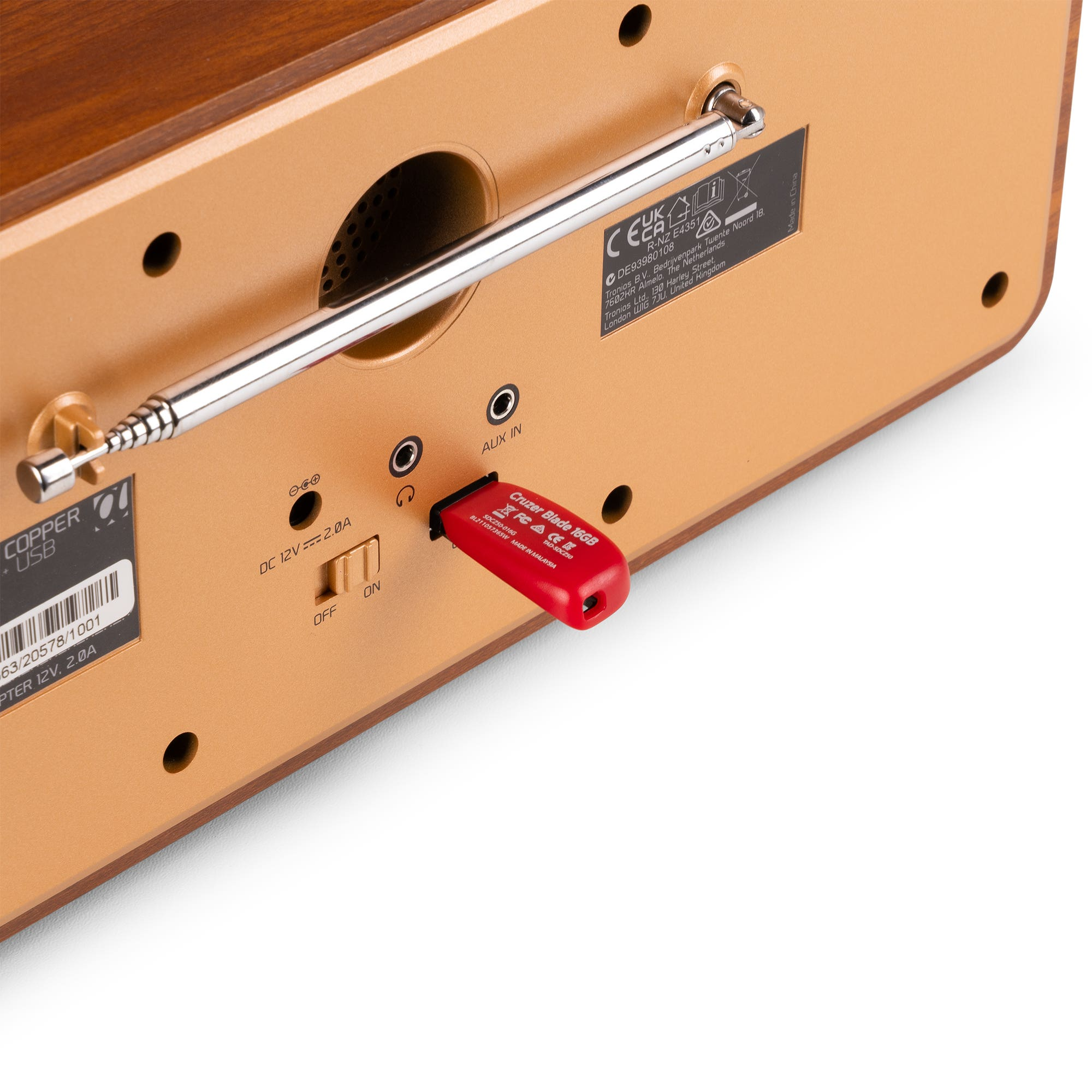 Primer plano de una radio de madera con una unidad USB roja insertada. Antena plateada y panel de control visibles.