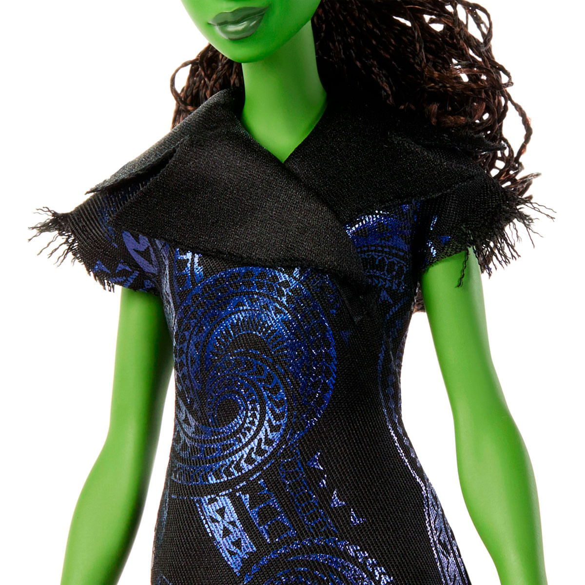 Una muñeca de piel verde con un vestido negro con patrones azules y un cuello negro. La muñeca tiene cabello castaño y está sobre un fondo blanco.