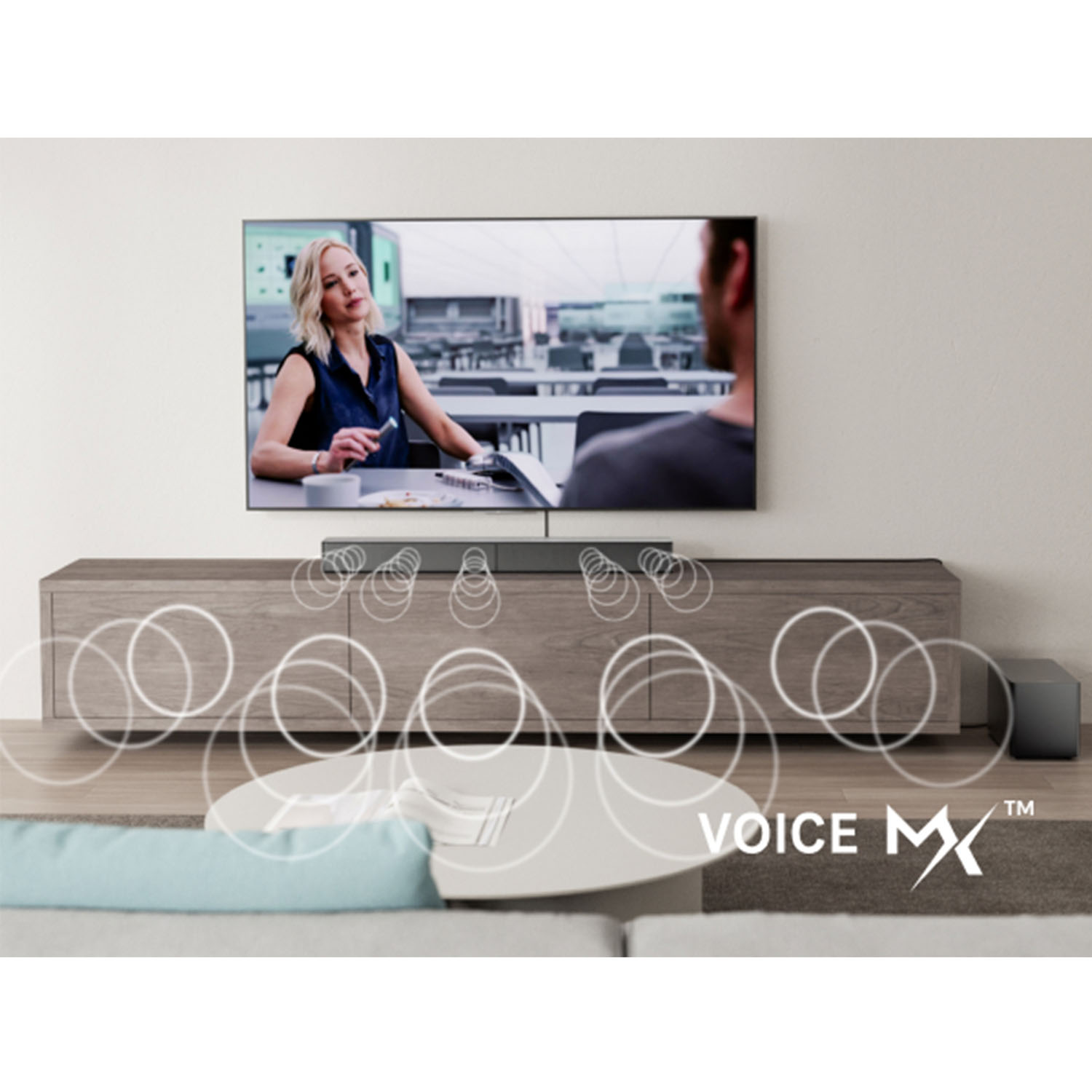 Telewizor wyświetla kobietę. Fale dźwiękowe emanują z soundbaru na drewnianej szafce. Subwoofer po prawej.