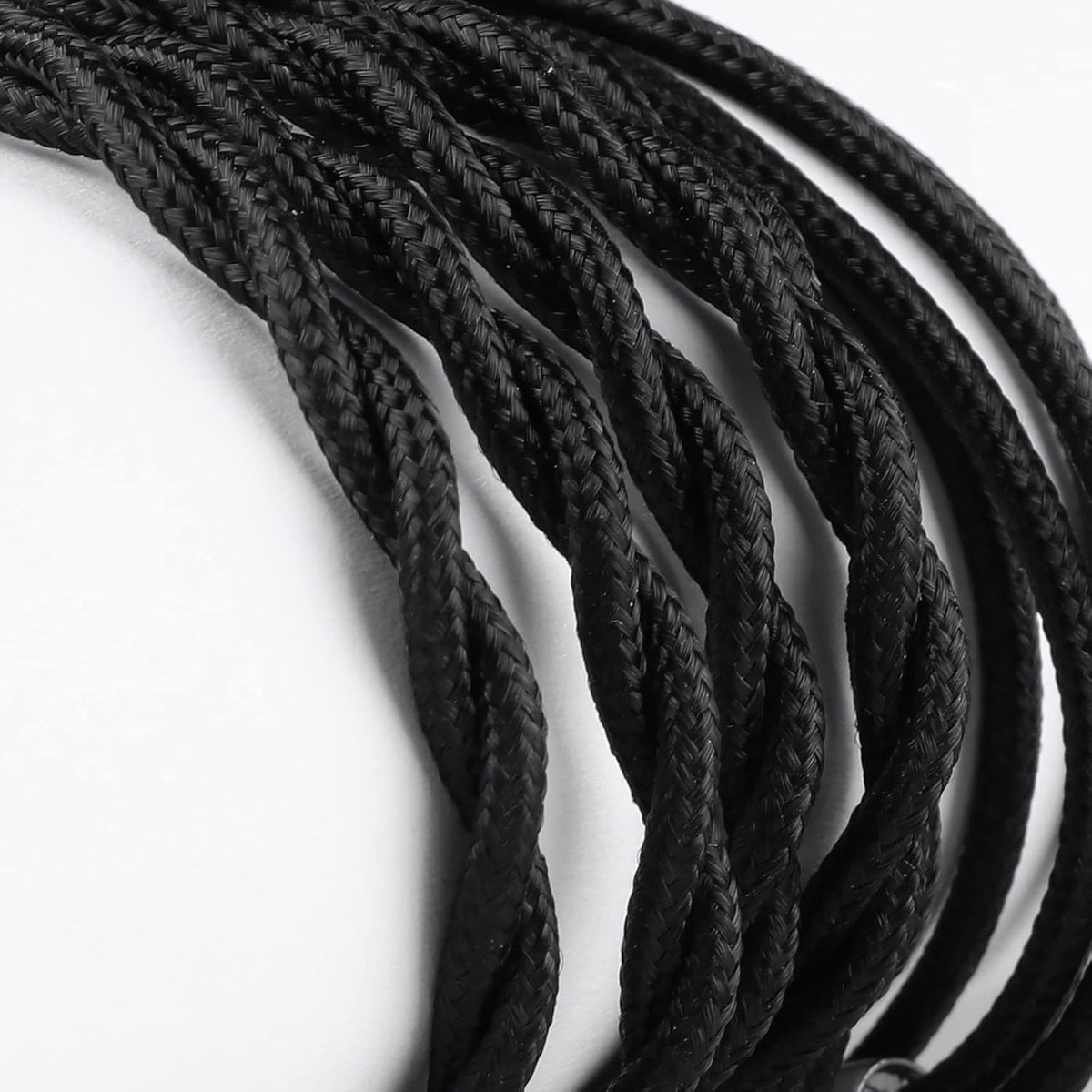 Primo piano di cavo elettrico nero intrecciato su sfondo bianco. Sono visibili diversi fili, strettamente intrecciati.