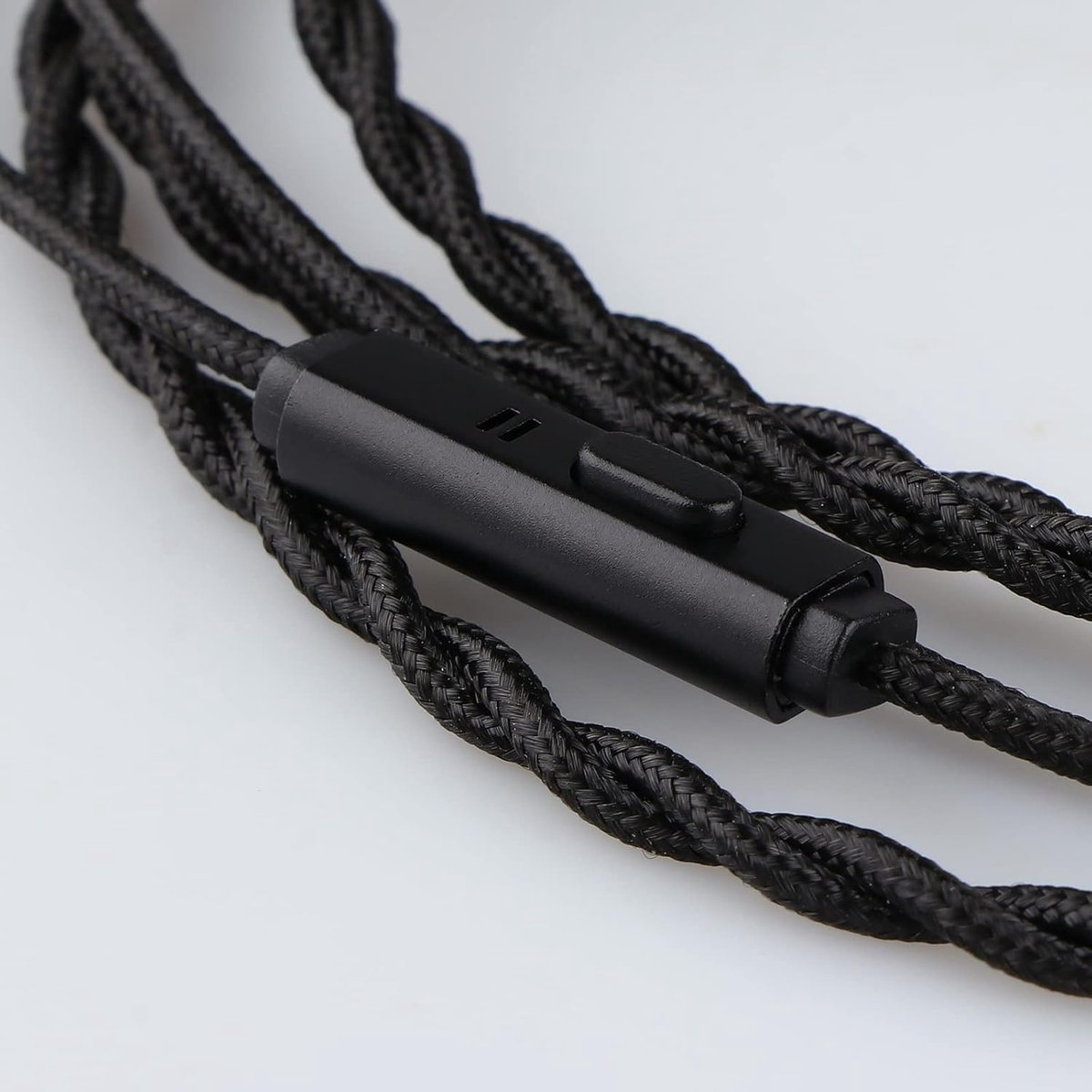 Primo piano di cavo per cuffie intrecciato nero con un elemento di controllo e un pulsante neri, su sfondo bianco.