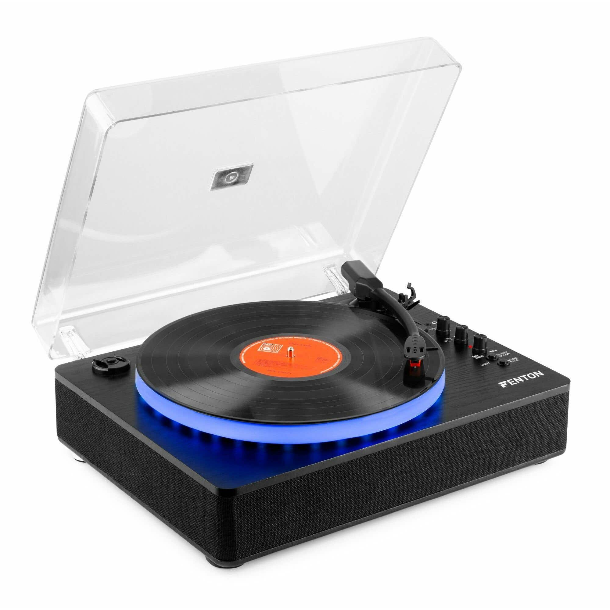 Tocadiscos con disco en reproducción. Base negra con luz azul, tapa transparente abierta. La marca es FENTON.