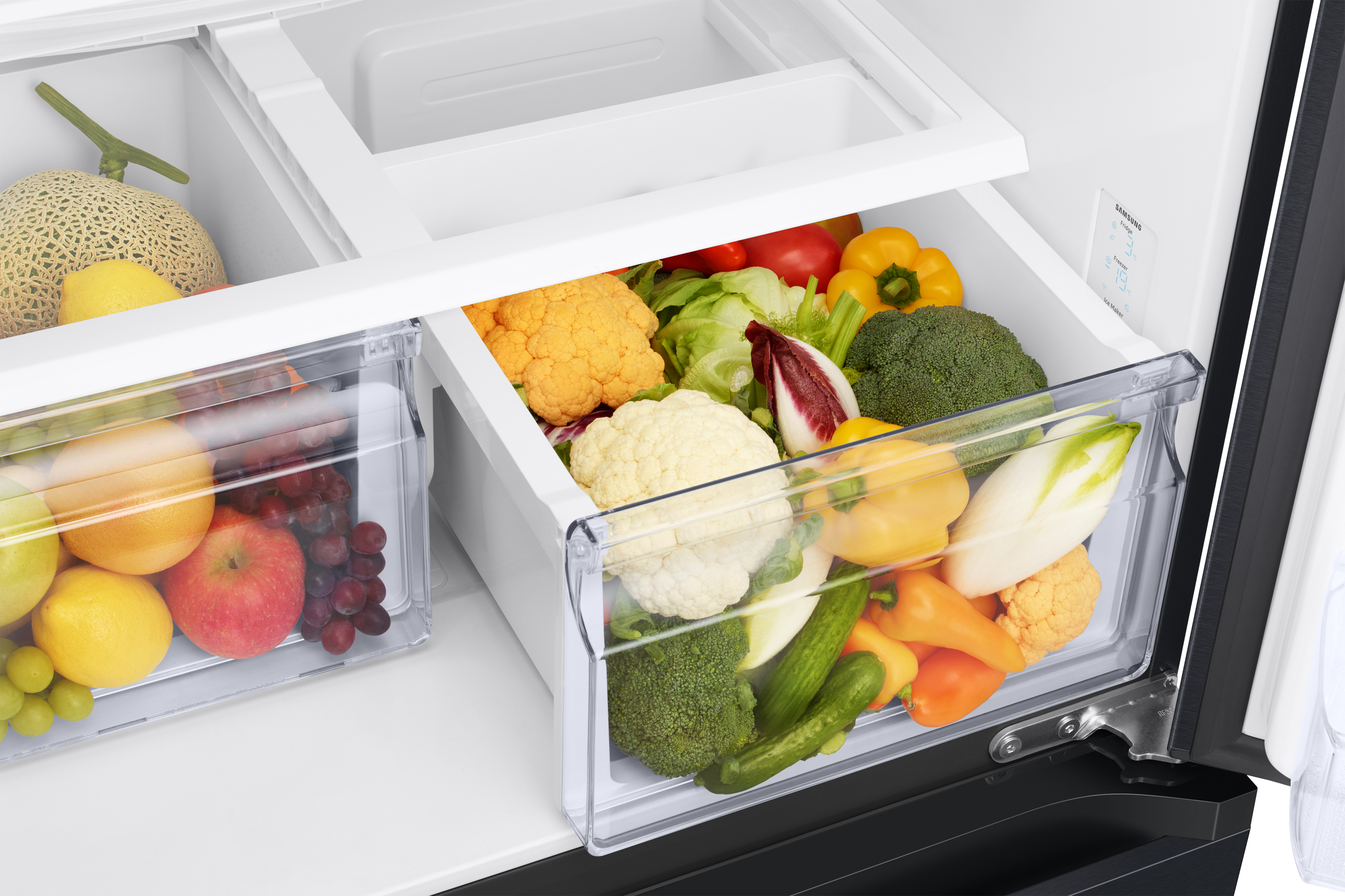Interieur van koelkast met fruit en groenten. Inclusief meloen, appels, druiven, bloemkool, paprika's en broccoli.