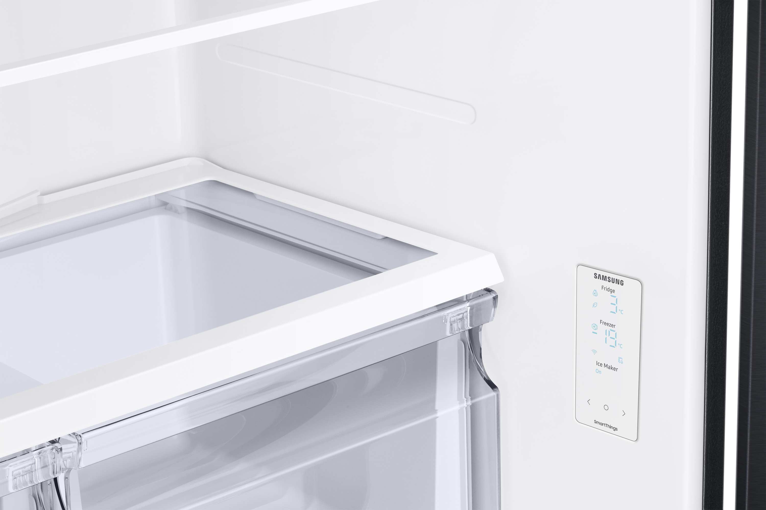Interieur van een Samsung koelkast. Toont een plank, een lade en een temperatuurweergave met koelkast- en vriezertemperaturen.