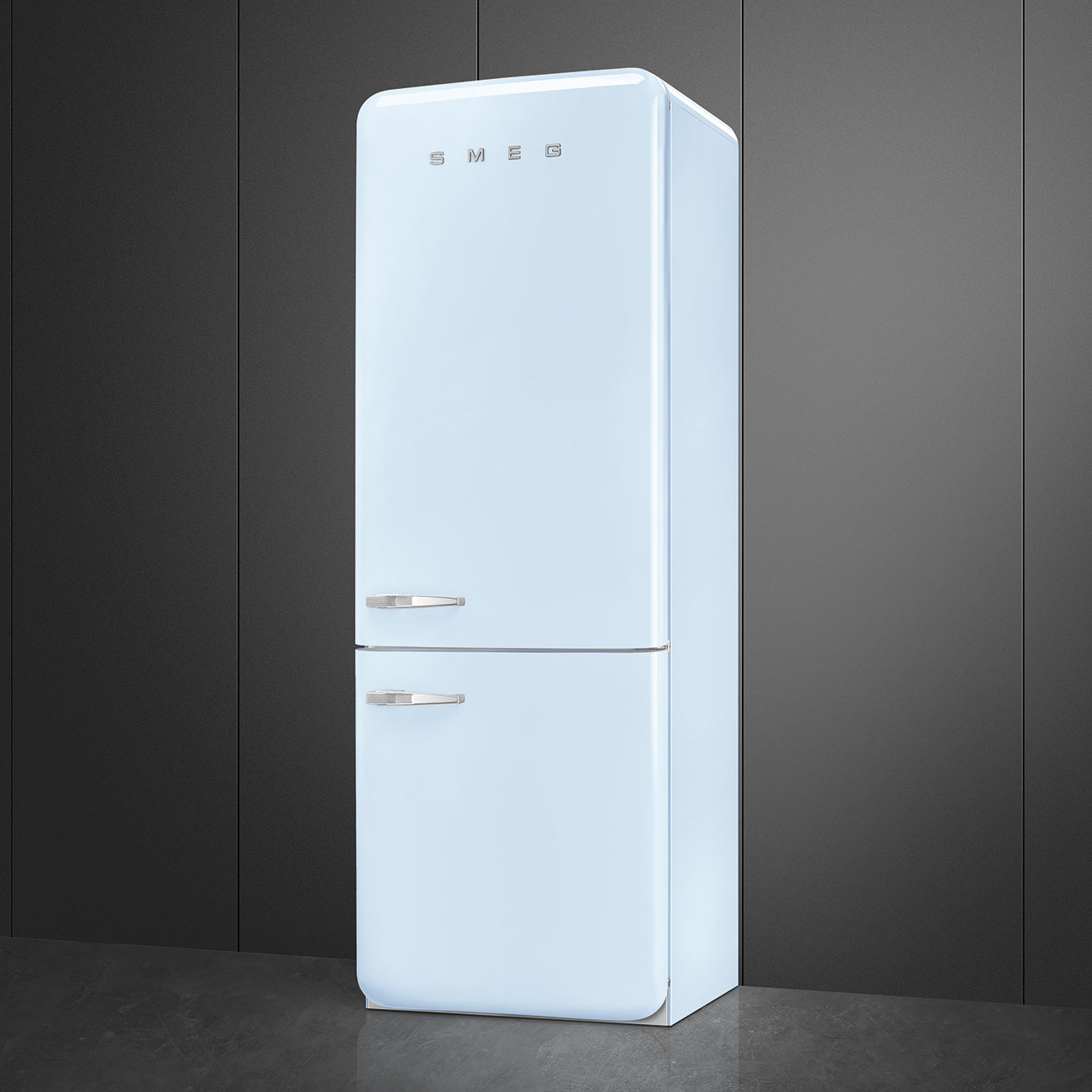 Un refrigerador SMEG azul claro se encuentra sobre un piso gris contra una pared gris oscuro. Tiene manijas plateadas y el logotipo de SMEG.
