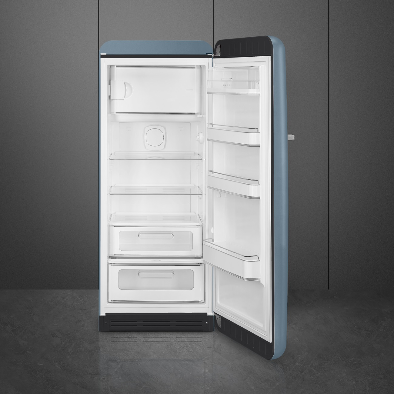 Ein blauer Retro-Kühlschrank mit offener Tür. Der Innenraum ist weiß mit Regalen und Schubladen. Der Hintergrund ist grau.