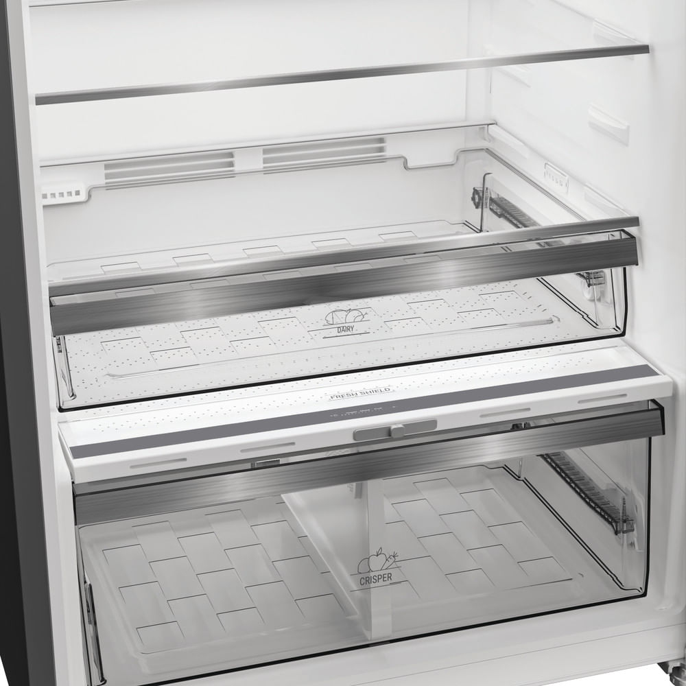 Interno di frigorifero aperto con cassetti e ripiani trasparenti. Etichette: 'Dairy' e 'Crisper'. Rifiniture argentate.