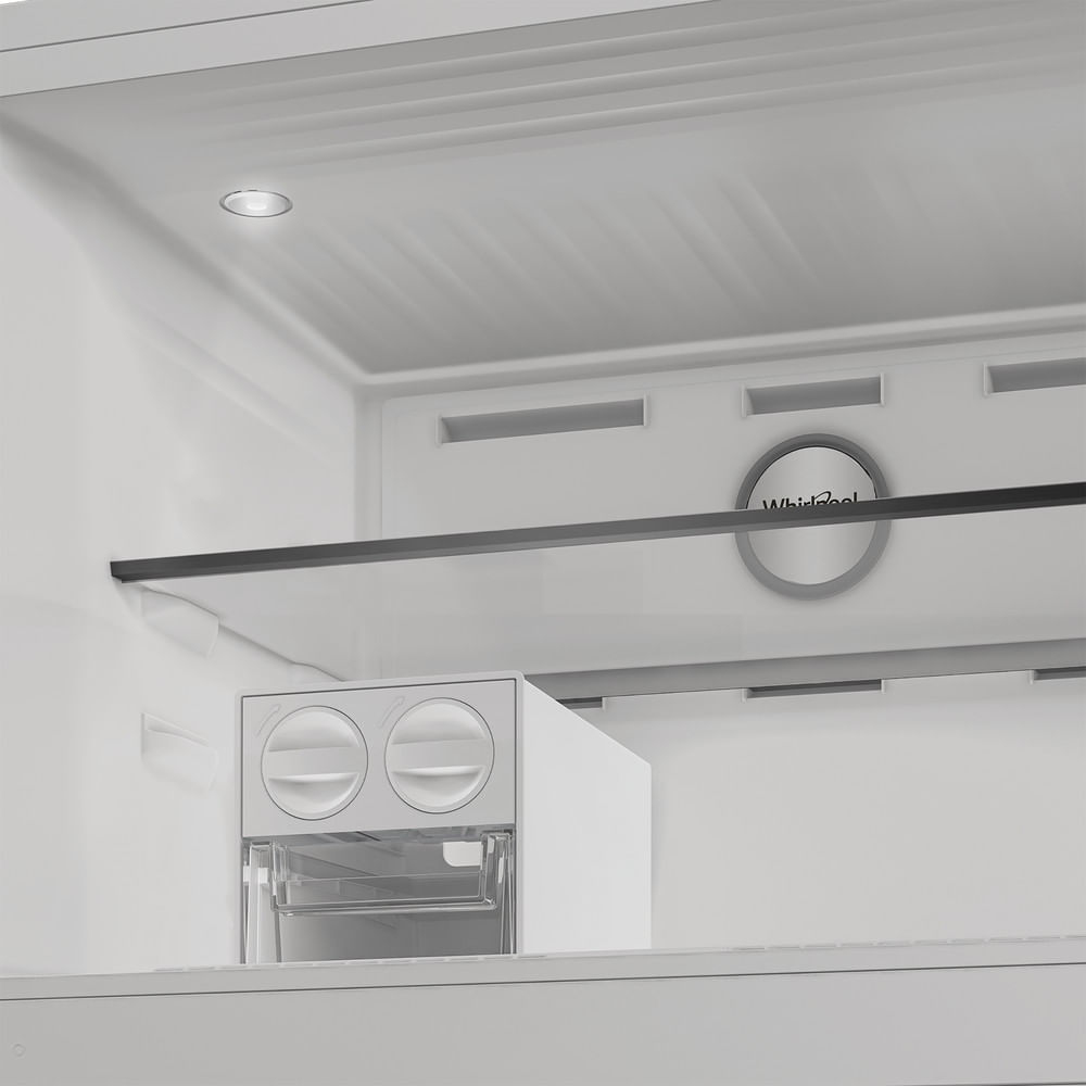 Interno di un frigorifero bianco. Ha una luce, ripiani e un distributore d'acqua. Logo Whirlpool visibile.