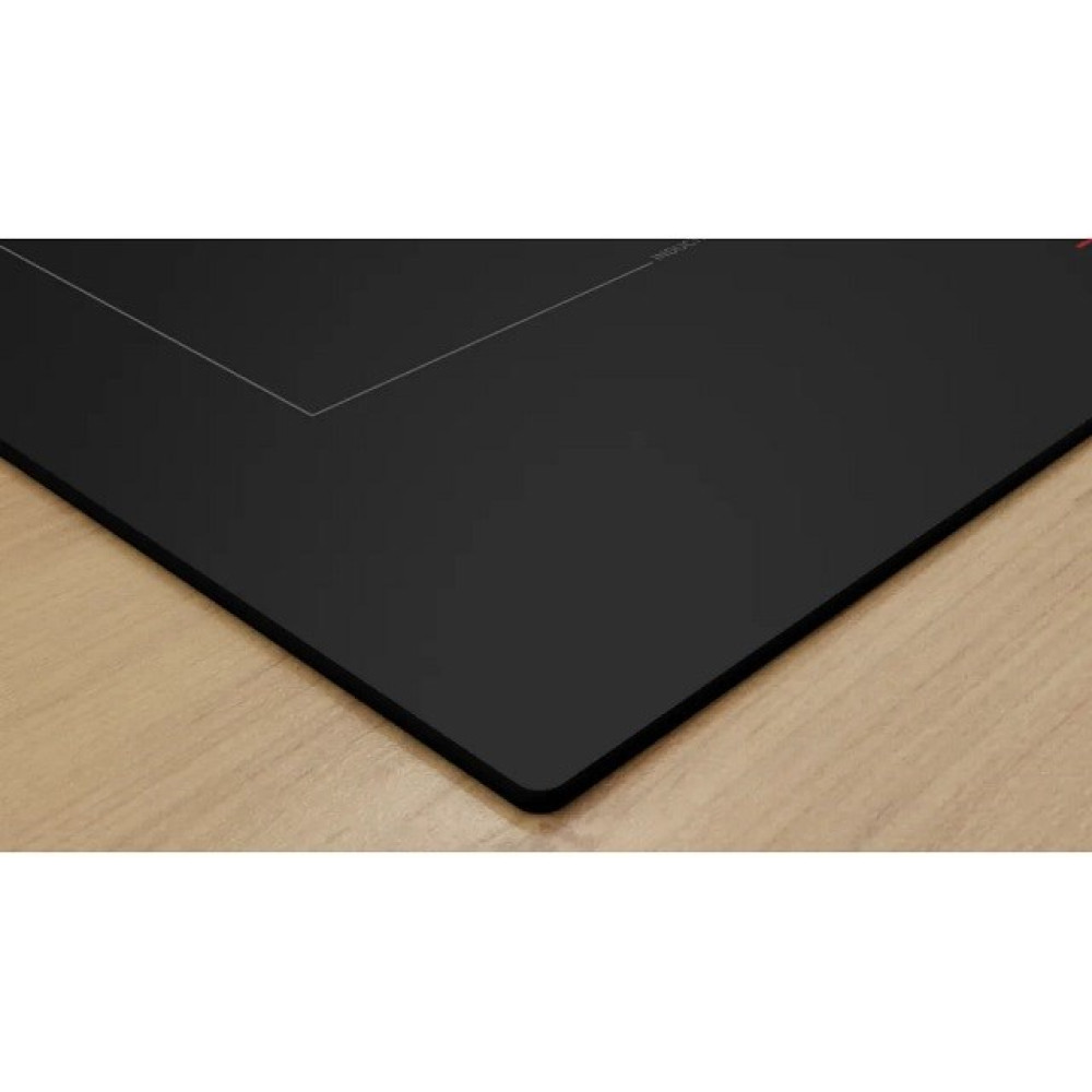 Zbliżenie czarnej płyty indukcyjnej. Płyta ma elegancki, nowoczesny design, ustawiony na drewnianej powierzchni.